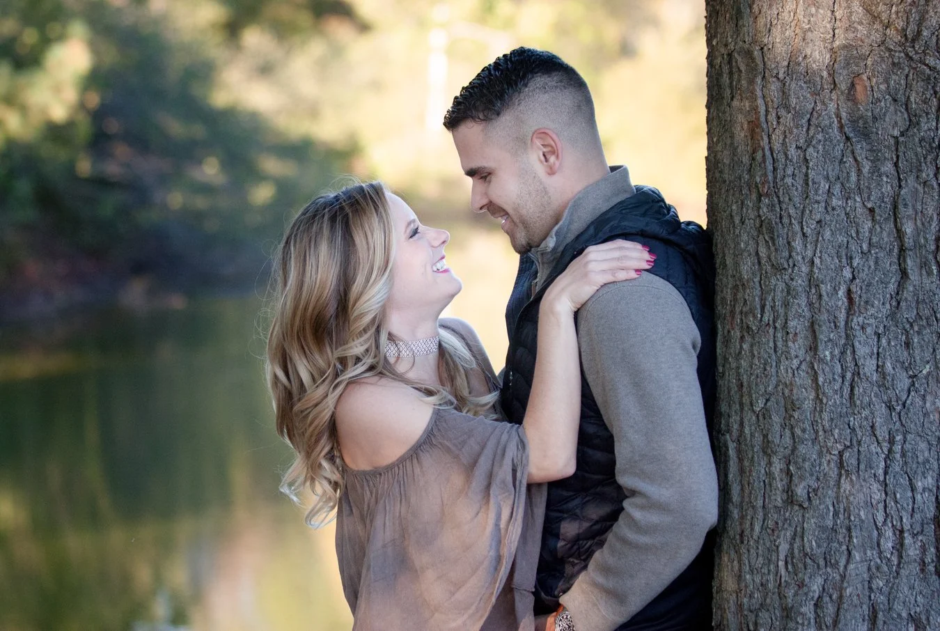 Candid moment of a couple laughing together in the fields at Chase Farm in Lincoln, Rhode Island — photographed by Courtney Wager Photography.