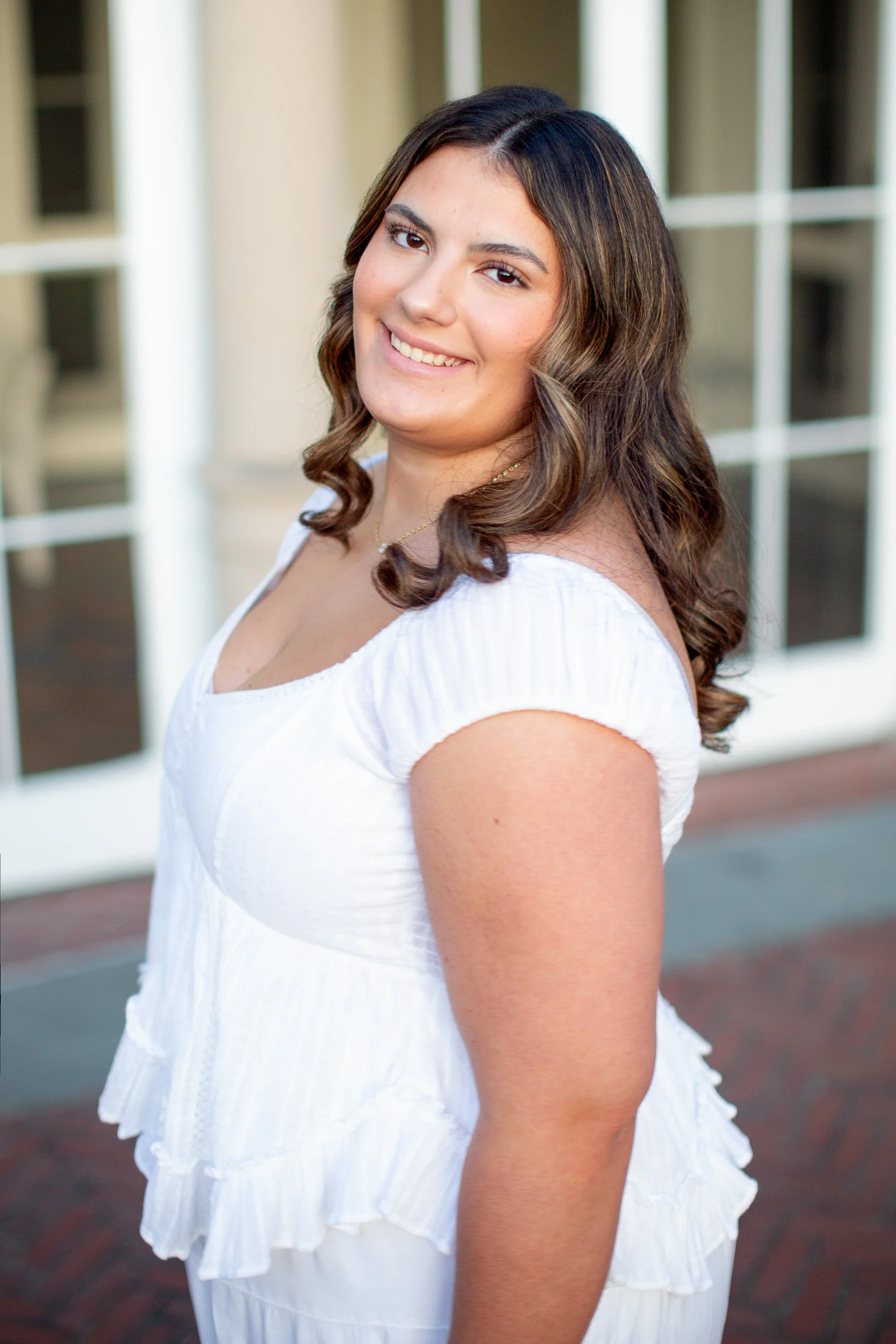 Senior portrait in a white dress outside Blithewold Mansion in Bristol, RI