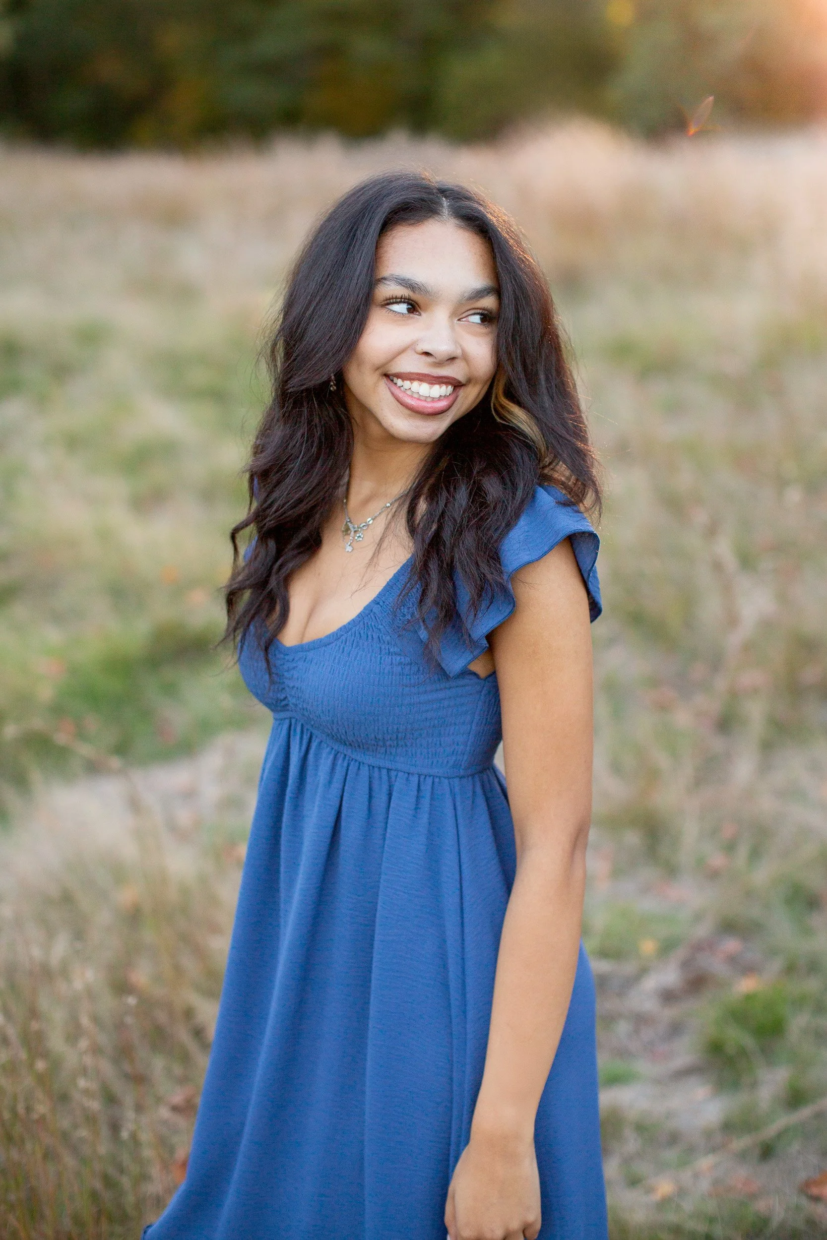 Maya posing outdoors at Bird Park in Walpole, Massachusetts, for her senior photos.