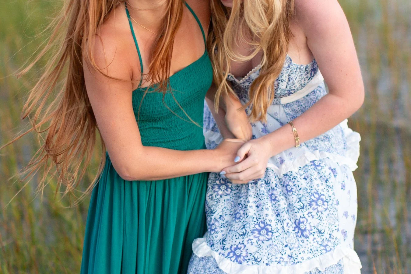 Best friends Dani and Cece holding hands while laughing during their senior photo session at Duxbury Beach in Massachusetts