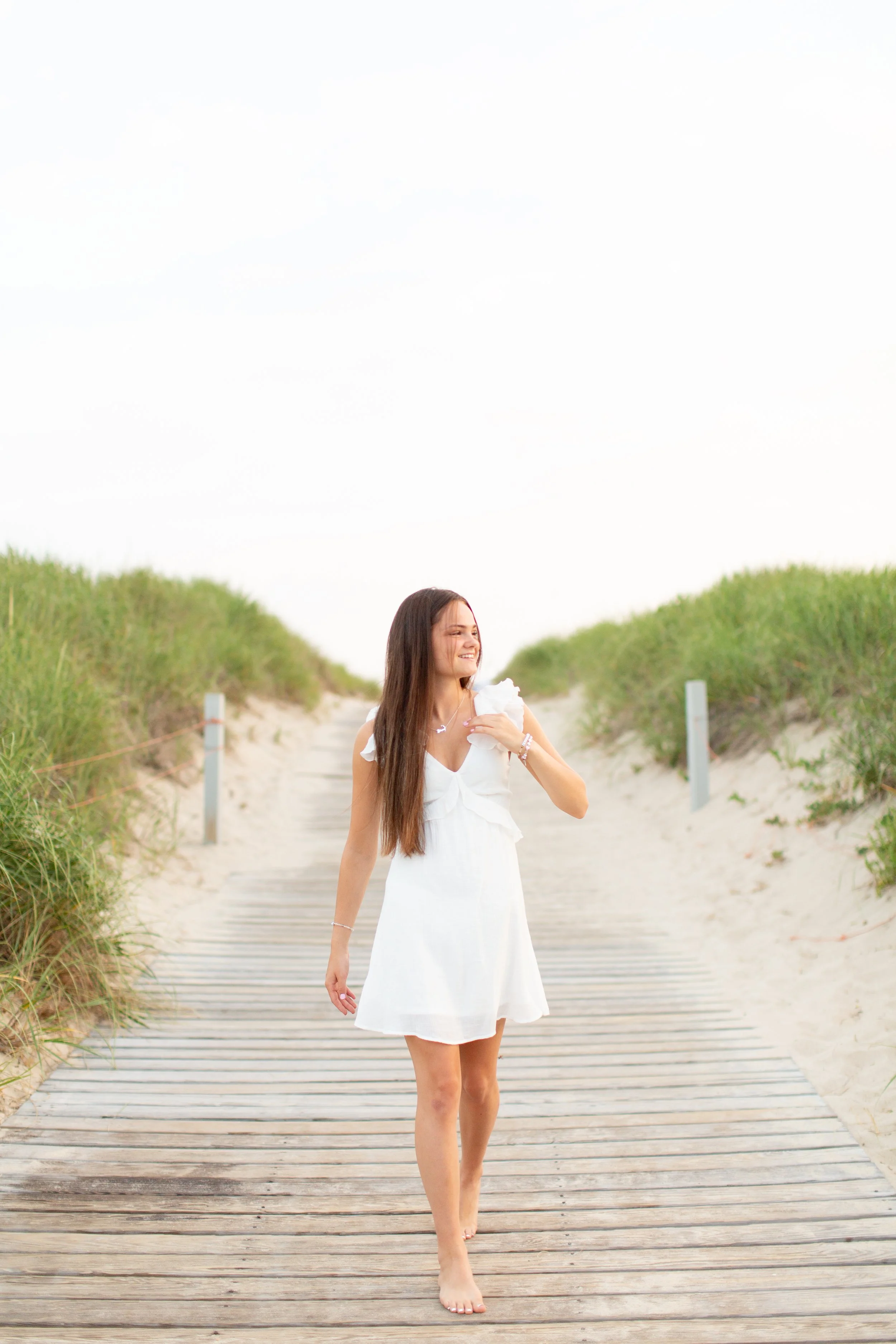 senior photos on the wooden boardwalk at Scusset Beach