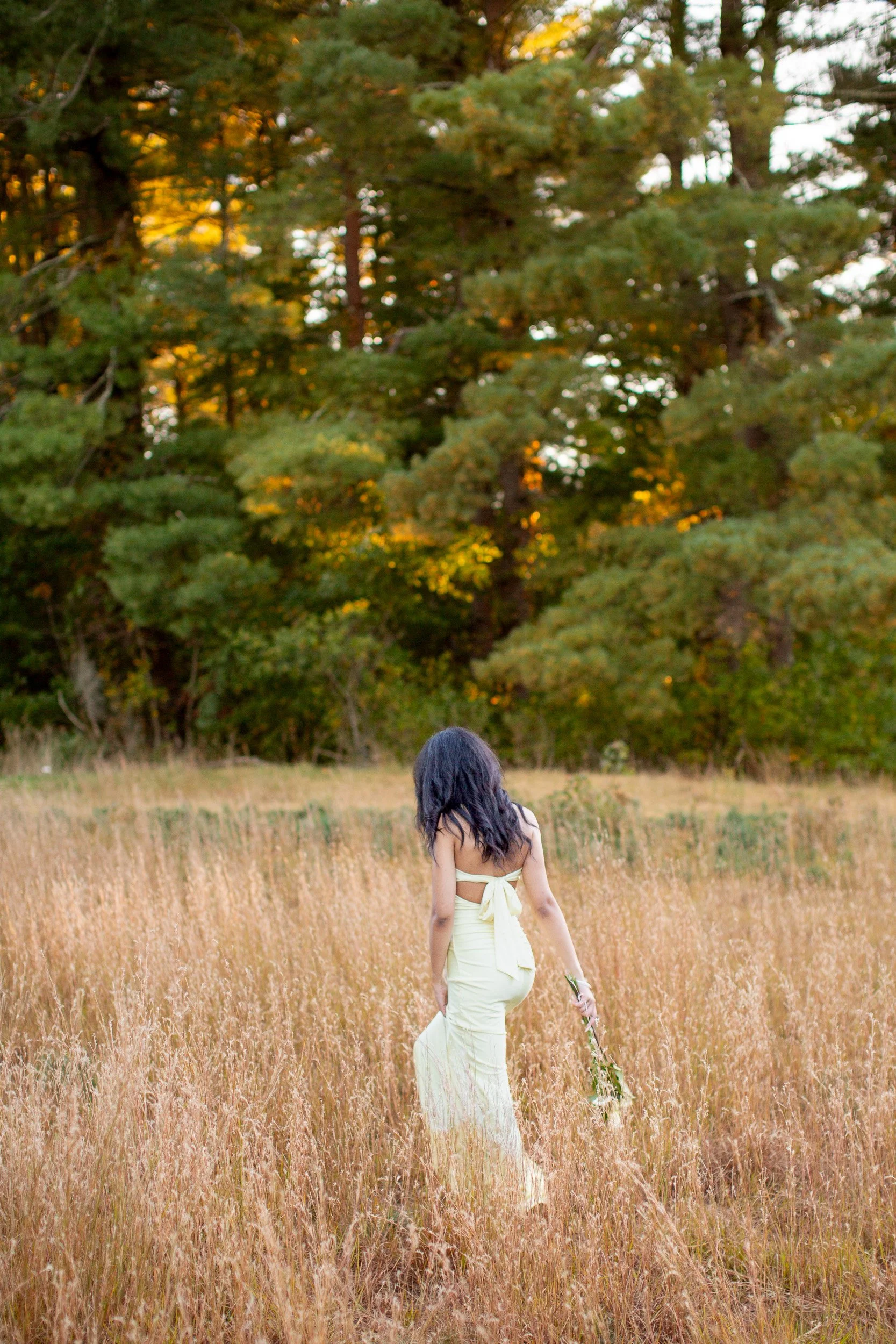 Maya walking along a park path during her senior photography session.