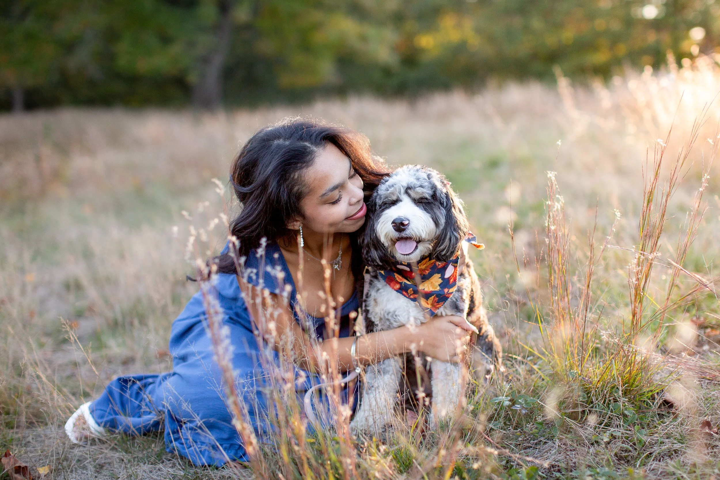 Senior portrait of Maya smiling with her dog Willow outdoors in Walpole, Massachusetts.
