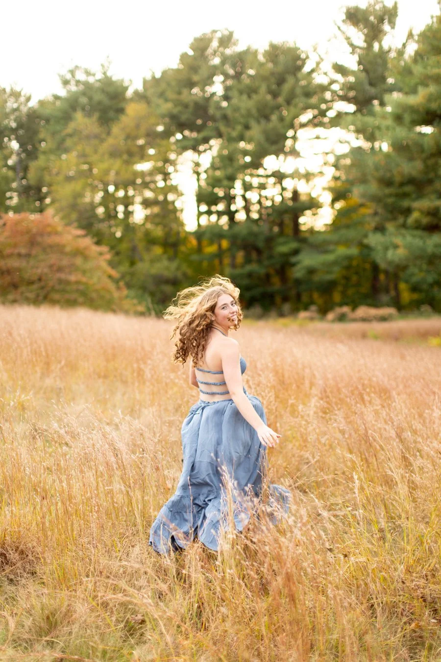 Senior girl running during fall portrait session at Bird Park in Walpole MA by Courtney Wager Photography.