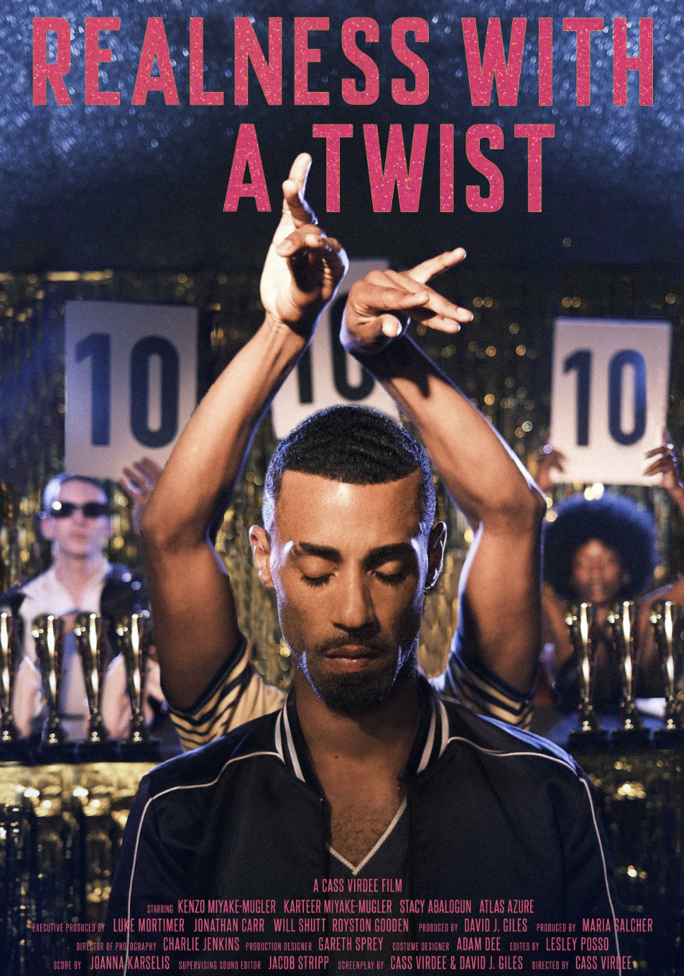 Poster for a film titled 'Realness with a Twist' featuring a young man with eyes closed, head slightly bowed, and arms raised with hands in expressive gestures, set against a backdrop of a glittery gold and blue stage with people holding up signs with the number '10' in the background.