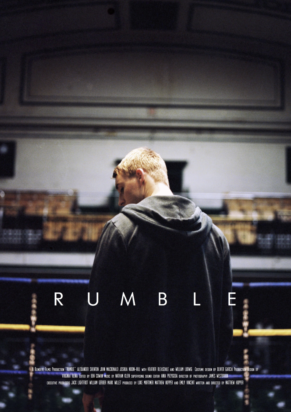 Poster for the film 'Rumble' featuring a young man with blonde hair in a hoodie, standing in a dimly lit arena or gym.