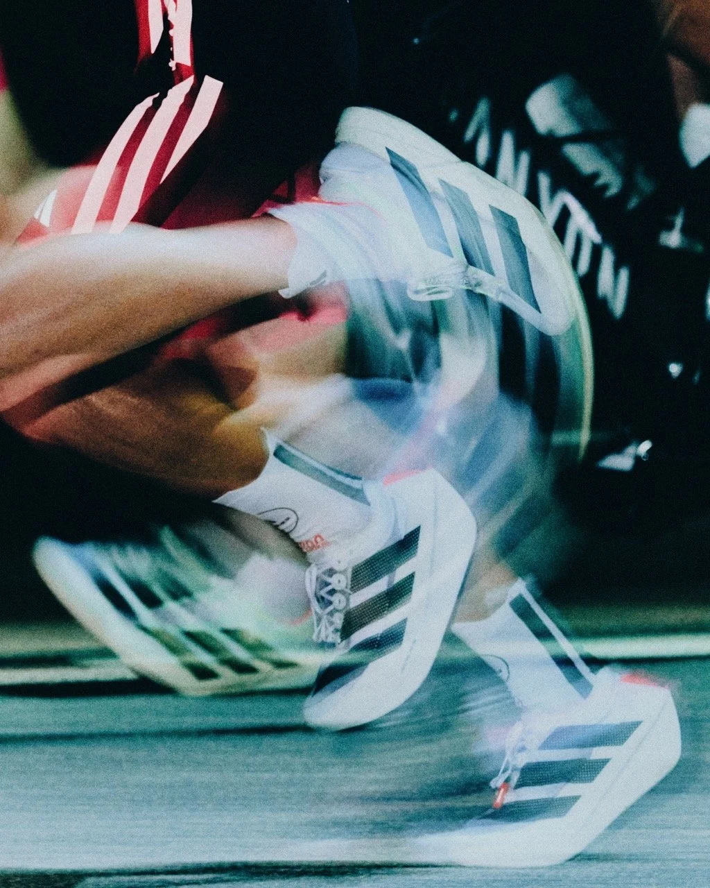 Close-up of Adidas sneakers in motion, causing a blurred, distorted effect.