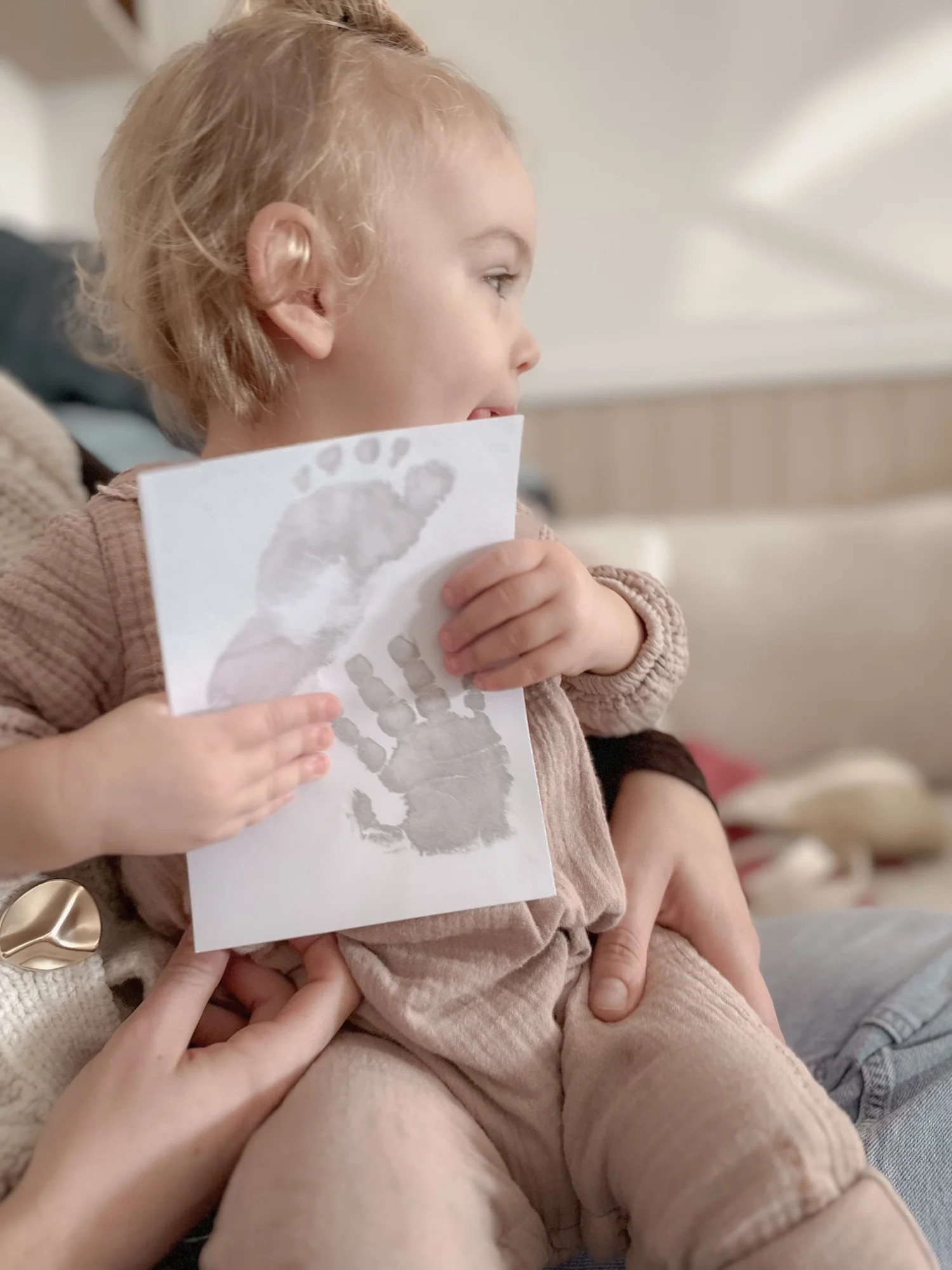 Enfant d'un an tenant sa carte d'empreinte de main