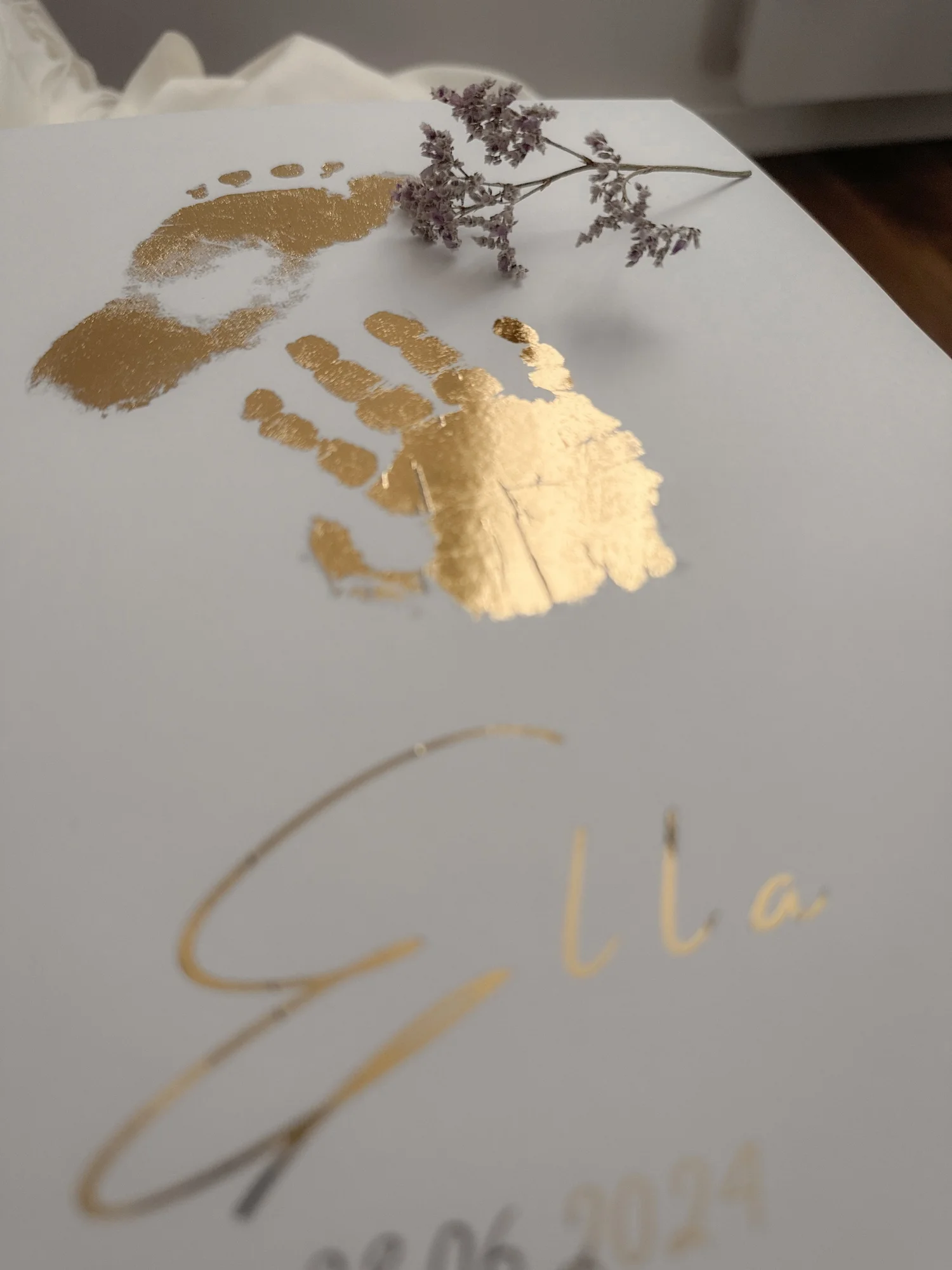 Détail d'une empreinte de main de bébé en dorure sur affiche personnalisée, idée cadeau de baptême