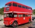 Red double-decker bus against a blue sky.