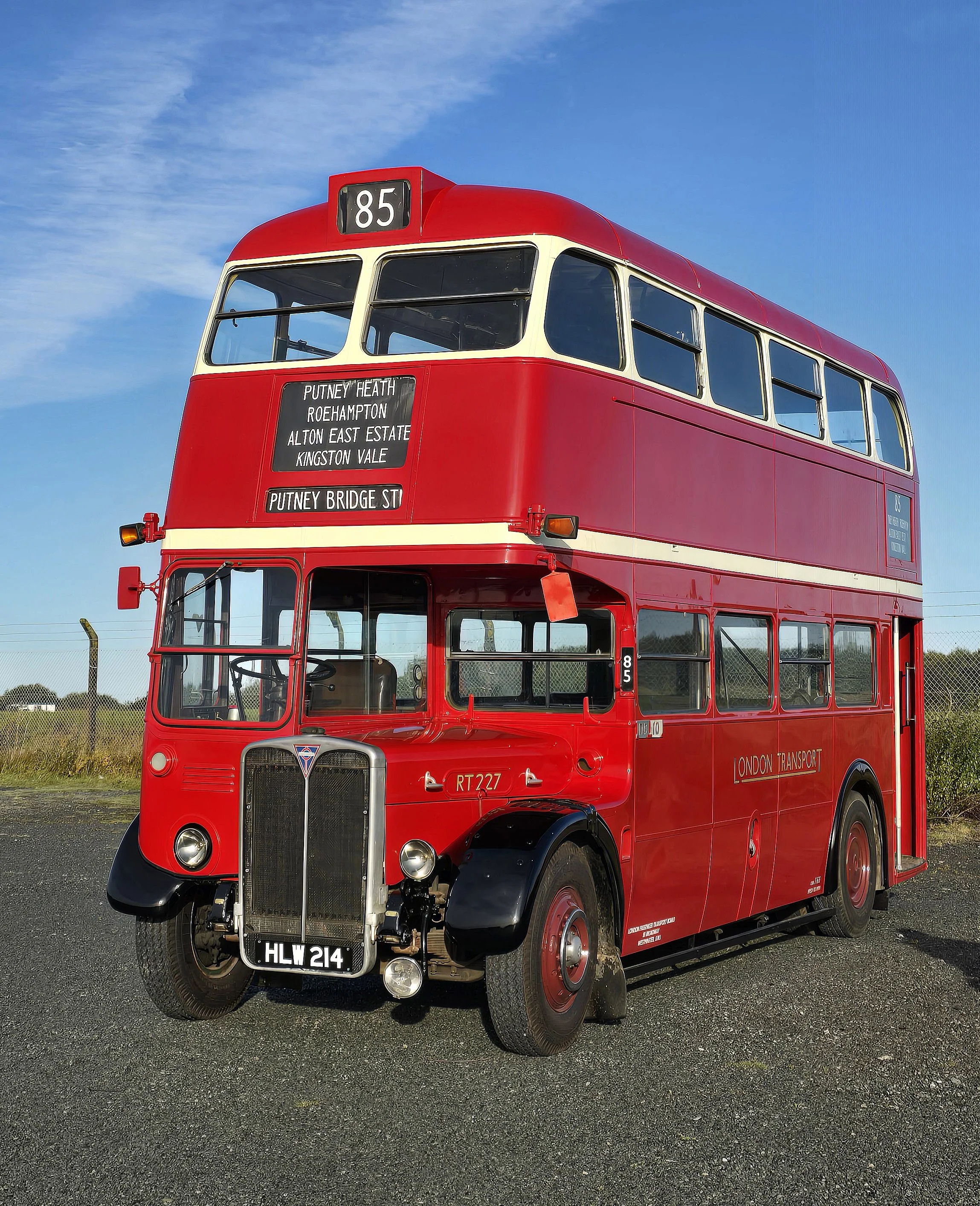 Red double-decker London bus on a clear day with blue sky, displaying route number 85 and destination signs for Putney Heath, Roehampton, Alton East Estate, Kingston Vale, and Putney Bridge Street.