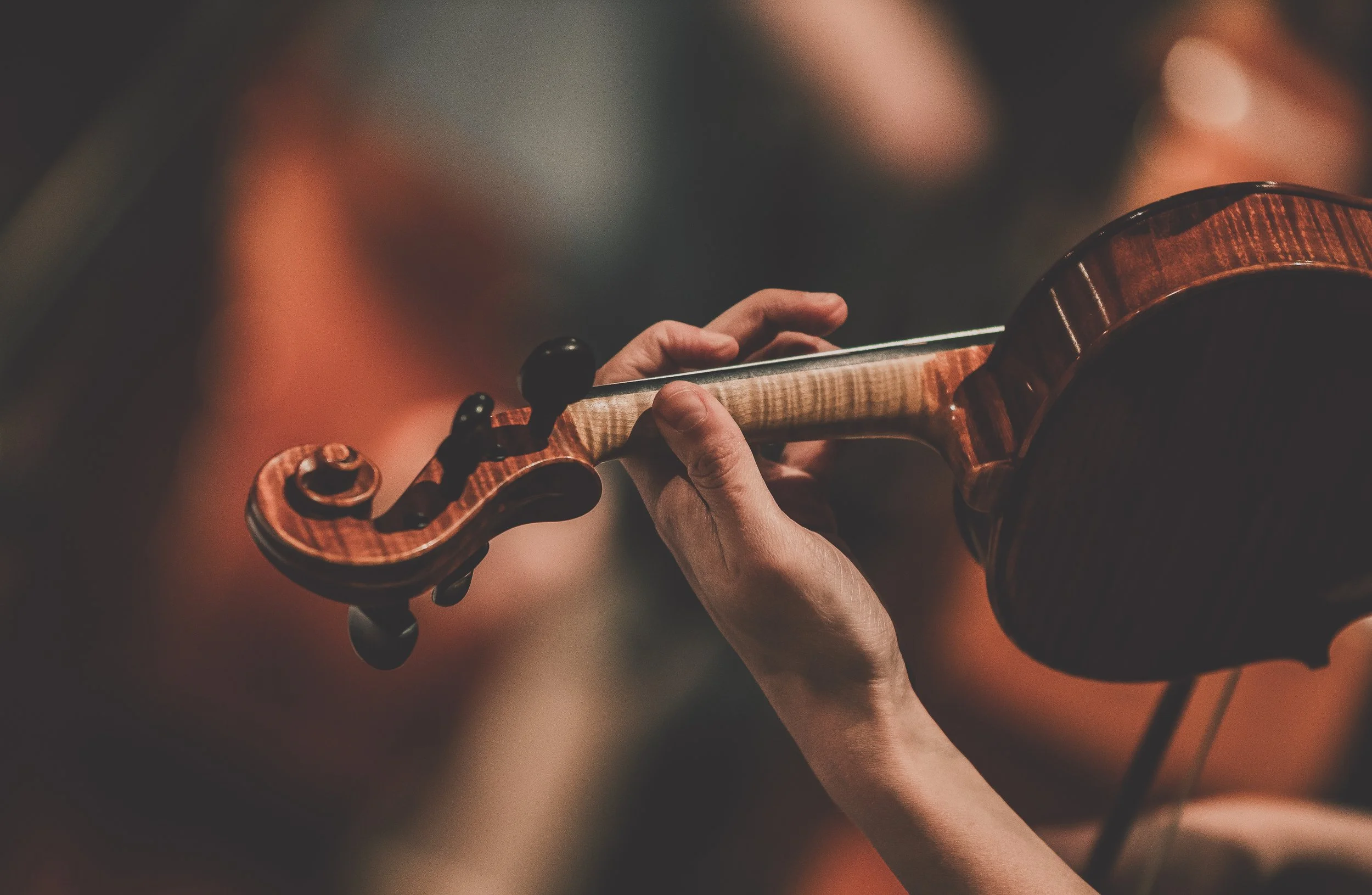 Close-up of a violinist’s left hand on the fingerboard, shaping an expressive historically informed sound.