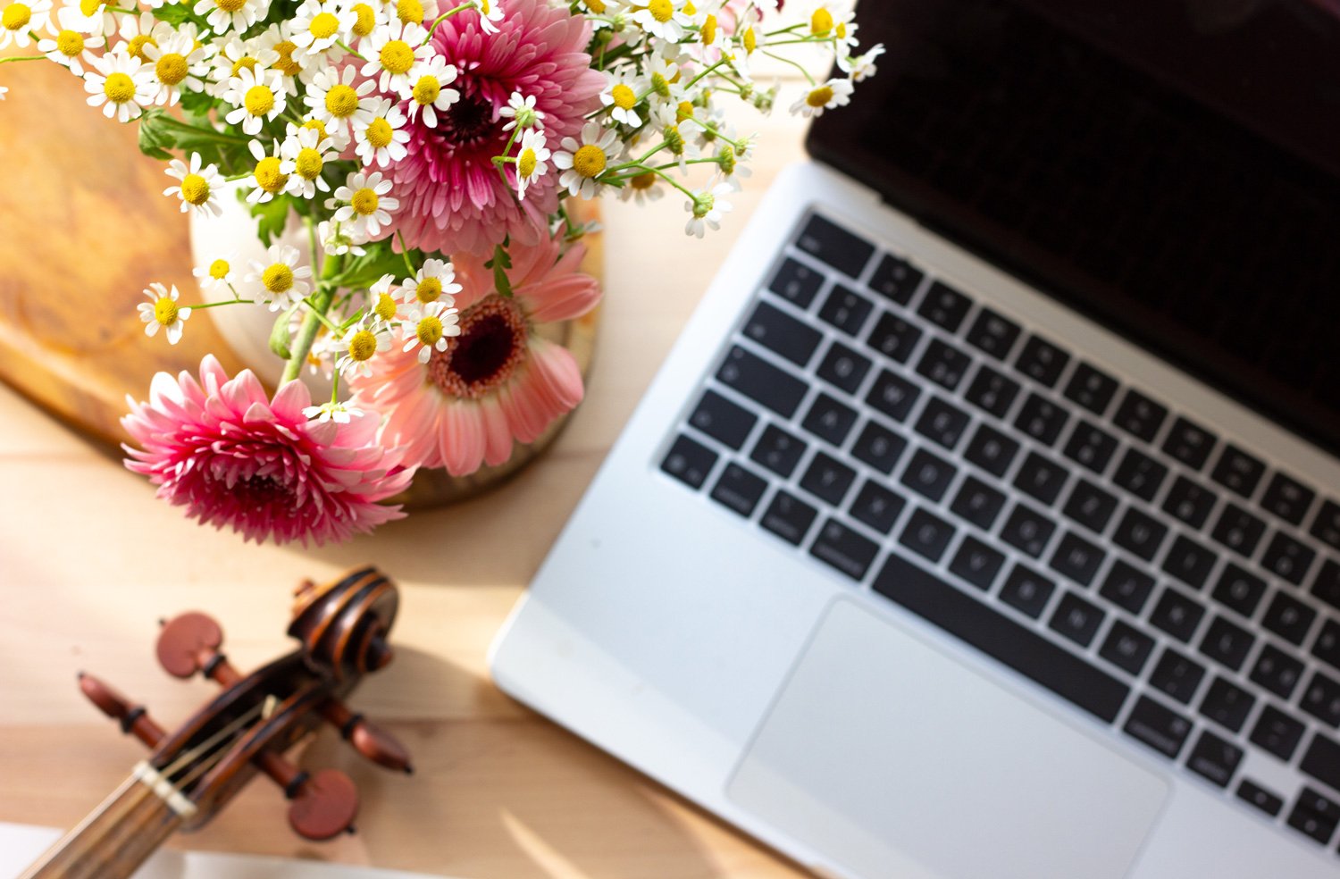 Laptop and violin on a home desk – online violin lesson setup at home