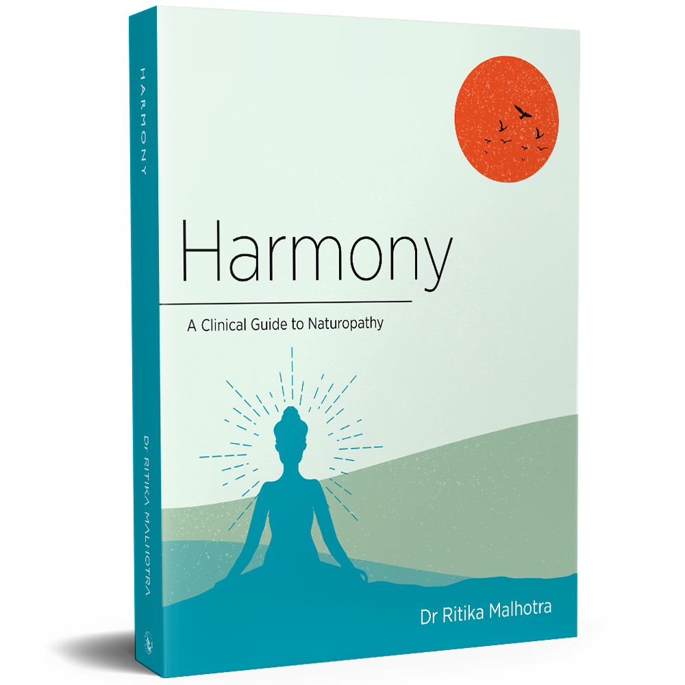 Book cover titled 'Harmony: A Clinical Guide to Naturopathy' by Dr. Ritika Malhotra, featuring a silhouette of a person meditating with rays emanating from their head and an orange sun with birds flying in the sky in the background.