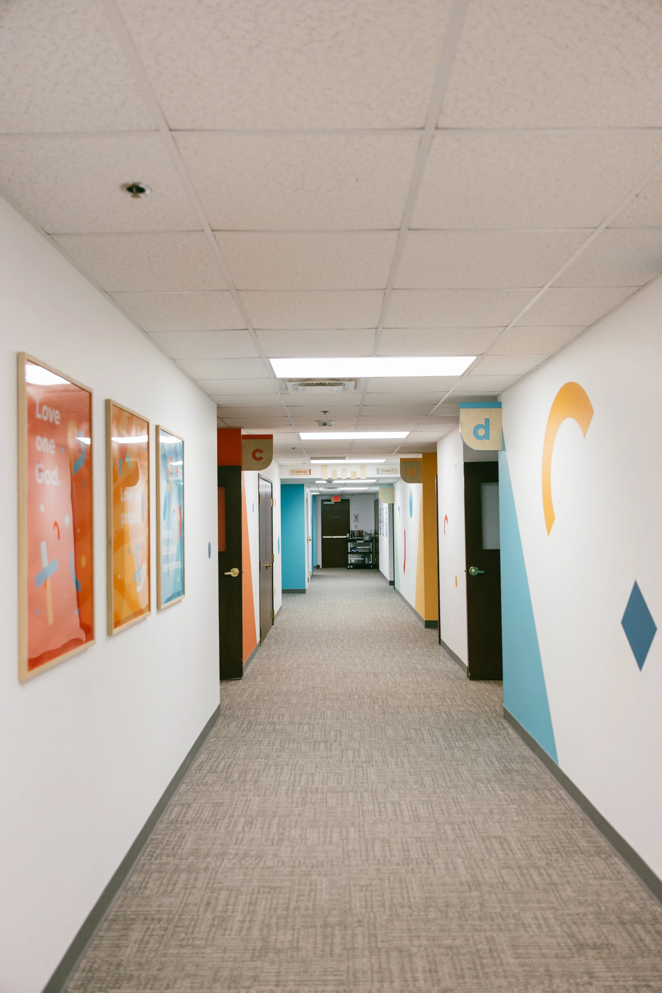 Eastside kids hallway, framed posters, room signs, vinyl graphics