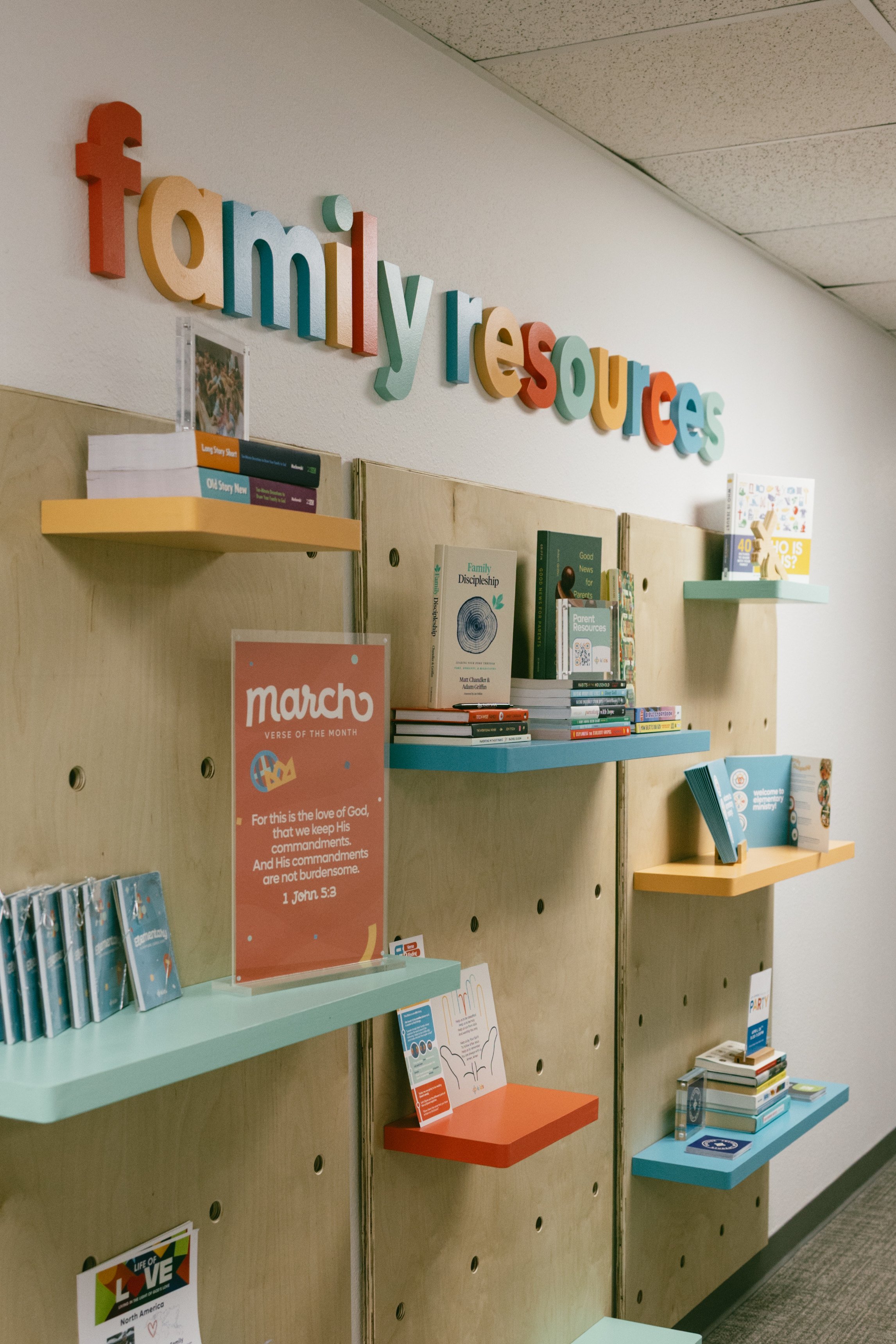 Eastside kids family resources wall. Custom lettering and pegboard with shelves
