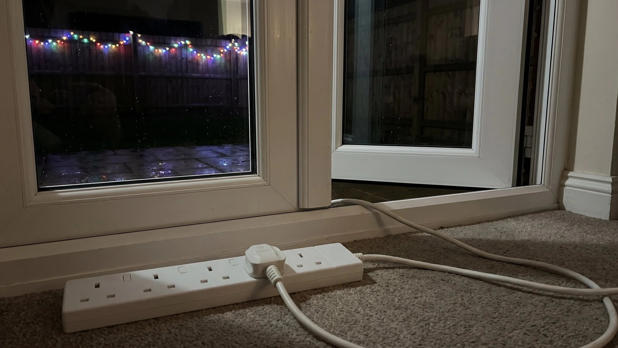 Extension lead trapped in a back door to power outdoor Christmas lights, a common safety hazard
