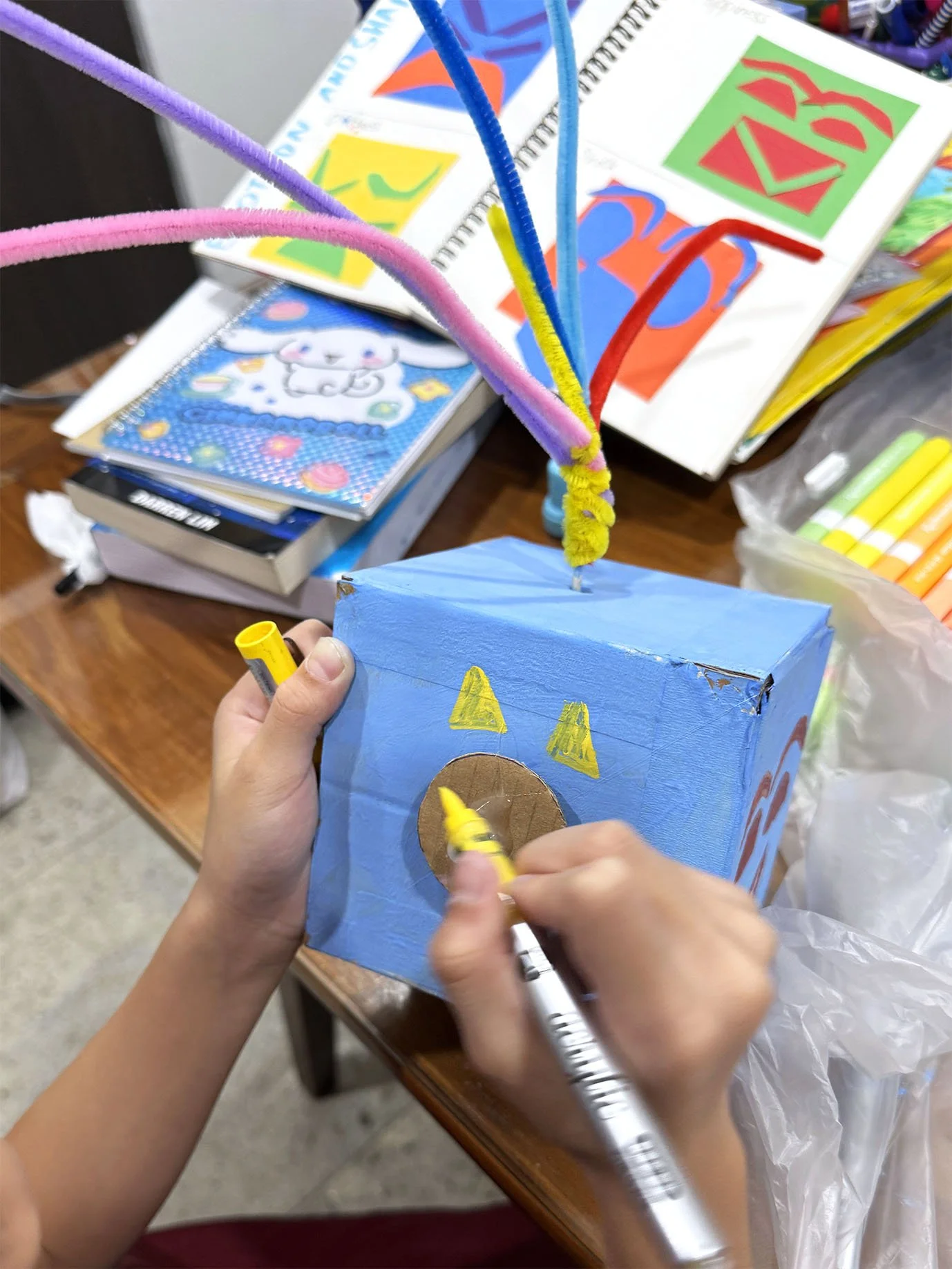 a child decorating his cardboard automata