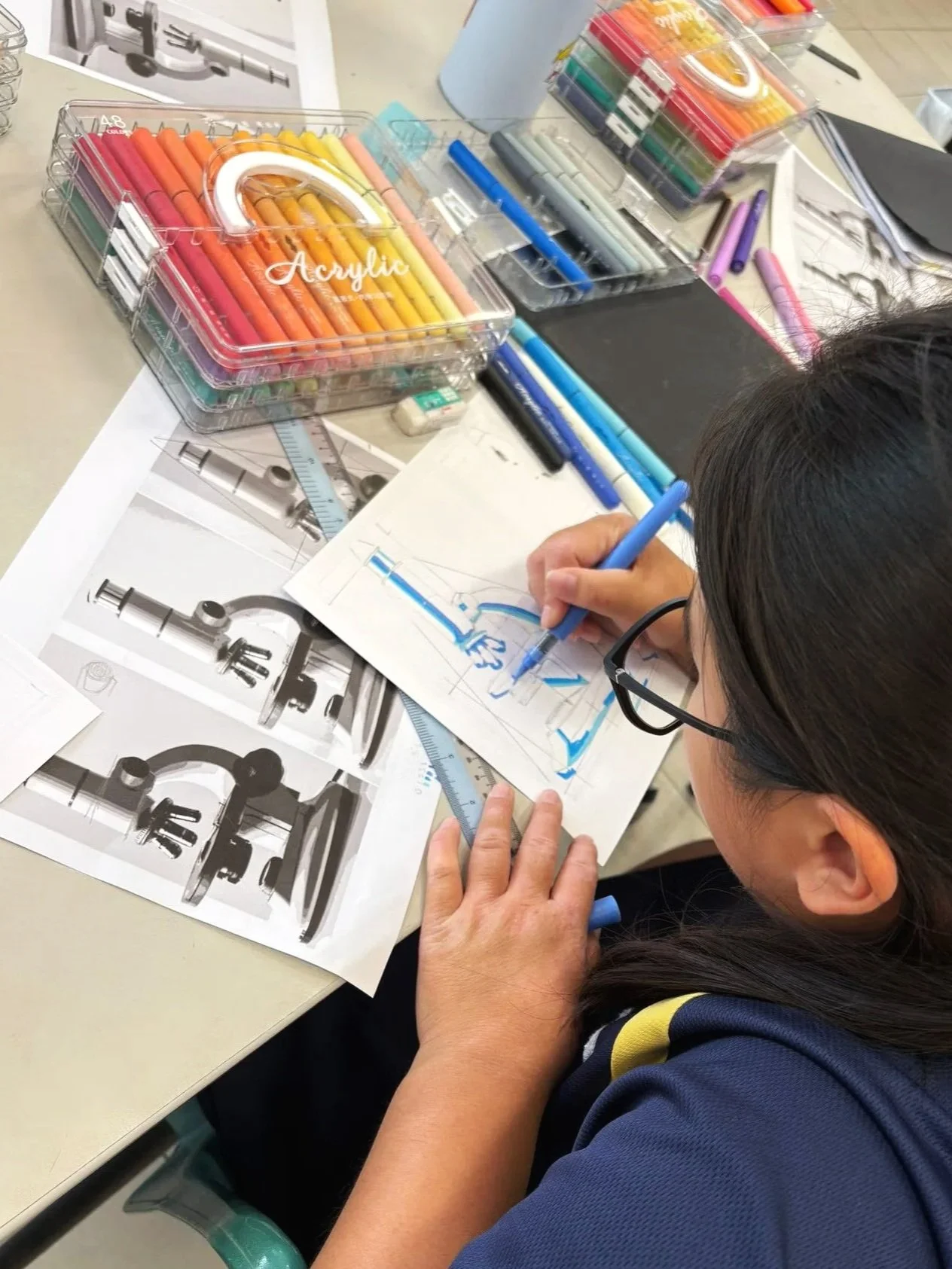 Student in singapore drawing microscope with acrylic markers