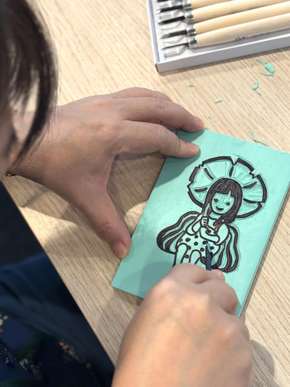 participant in the process of carving into a stamp block