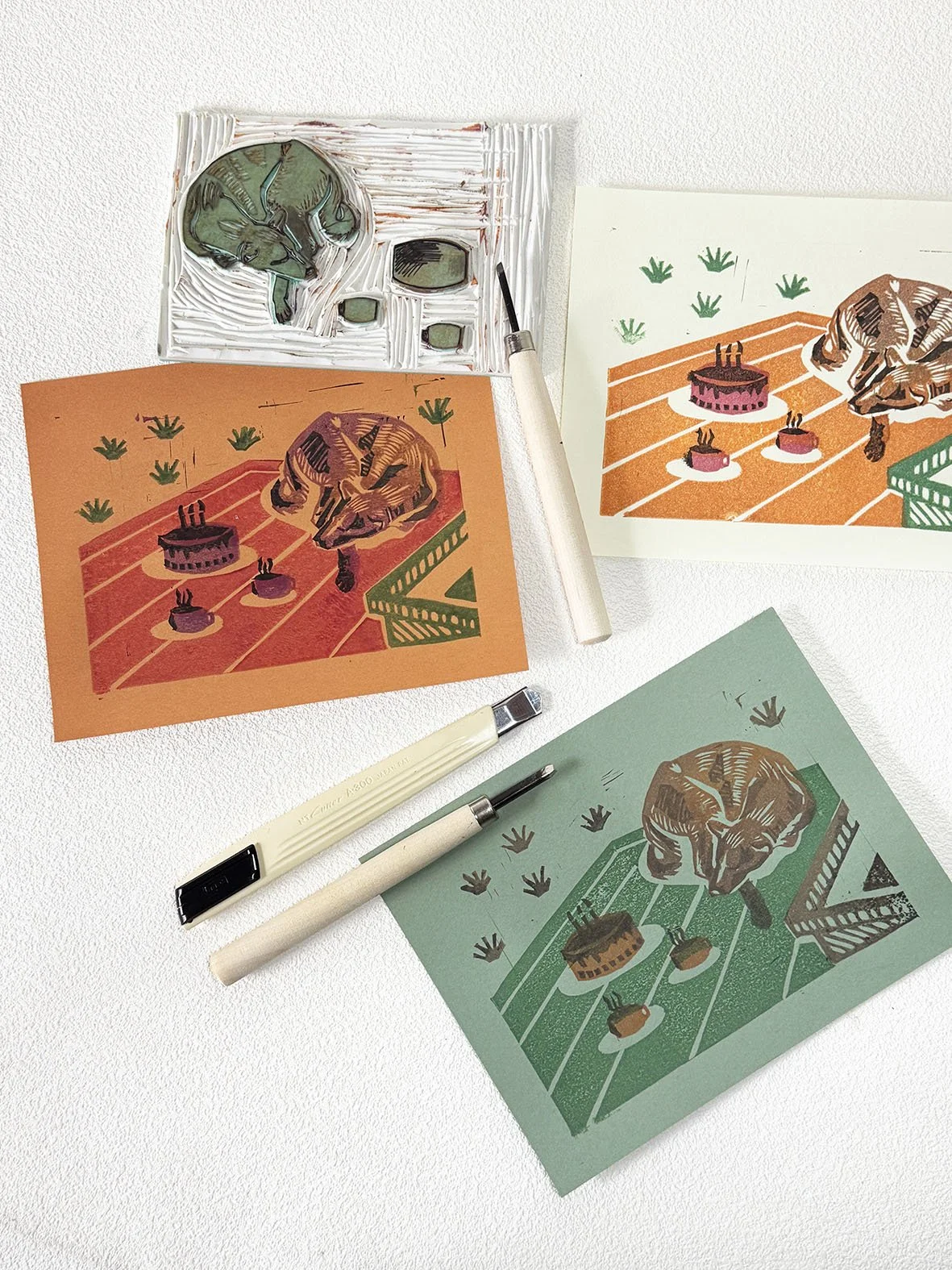 Stamp carving samples showing 3 coloured layer print of a dog on a picnic mat