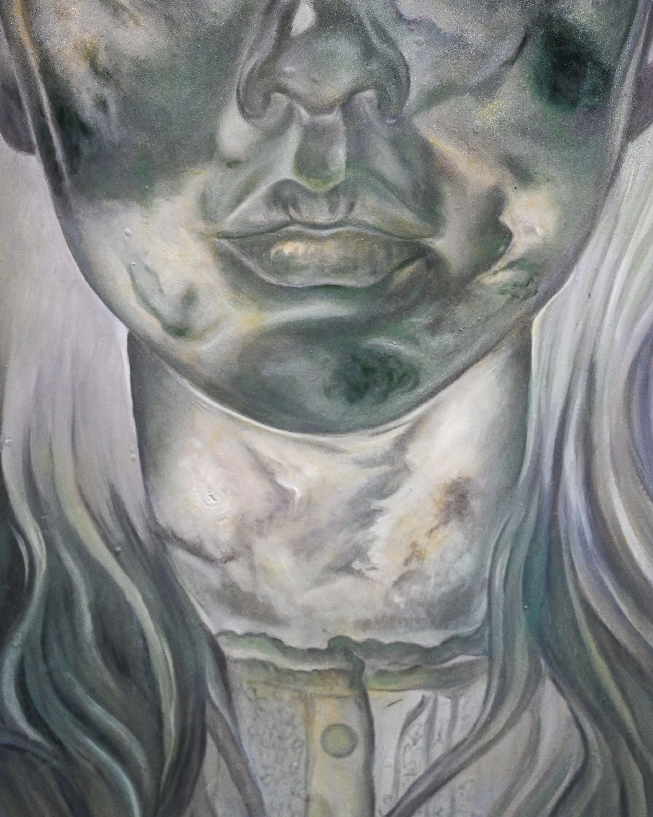 A close-up of a metallic sculpture of a human face, showing the nose, lips, and chin with detailed textured surface and some greenish and grayish coloring.