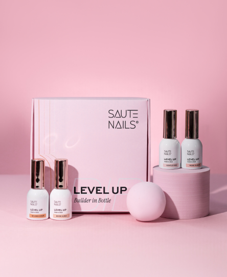 Set di prodotti per unghie SALTE NAILS con due bottiglie di smalto e una palla, tutto su uno sfondo rosa