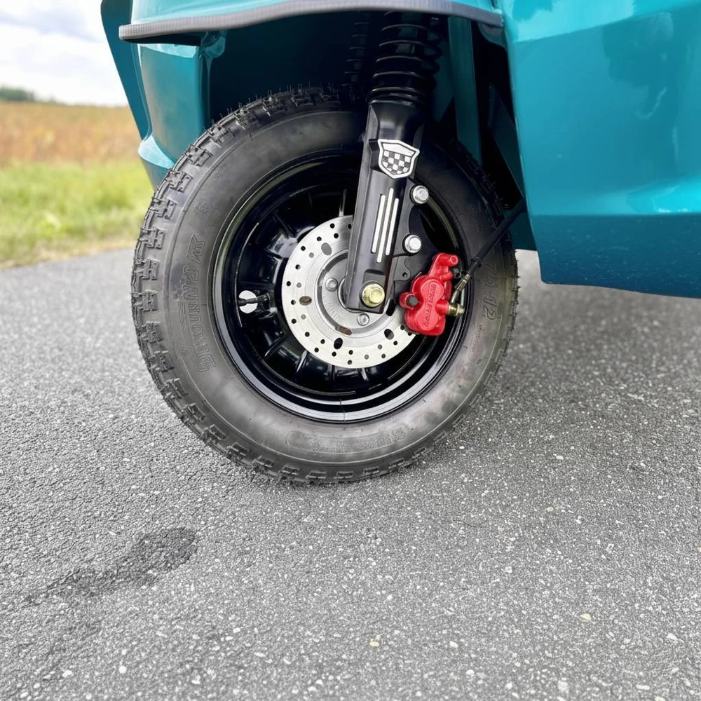 Nærbillede af forhjulet på en luxcap el-kabinescooter, der viser dækket, de sikre og kraftige bremser og affjedringen.