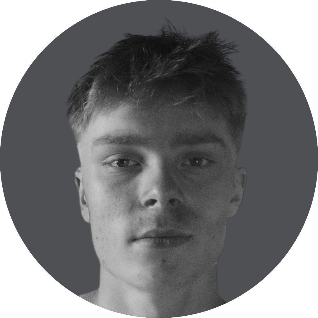 Sort-hvid portrætfotografi af en ung mand med kort, rodet hår og let ar på kinden, mod en mørk baggrund.