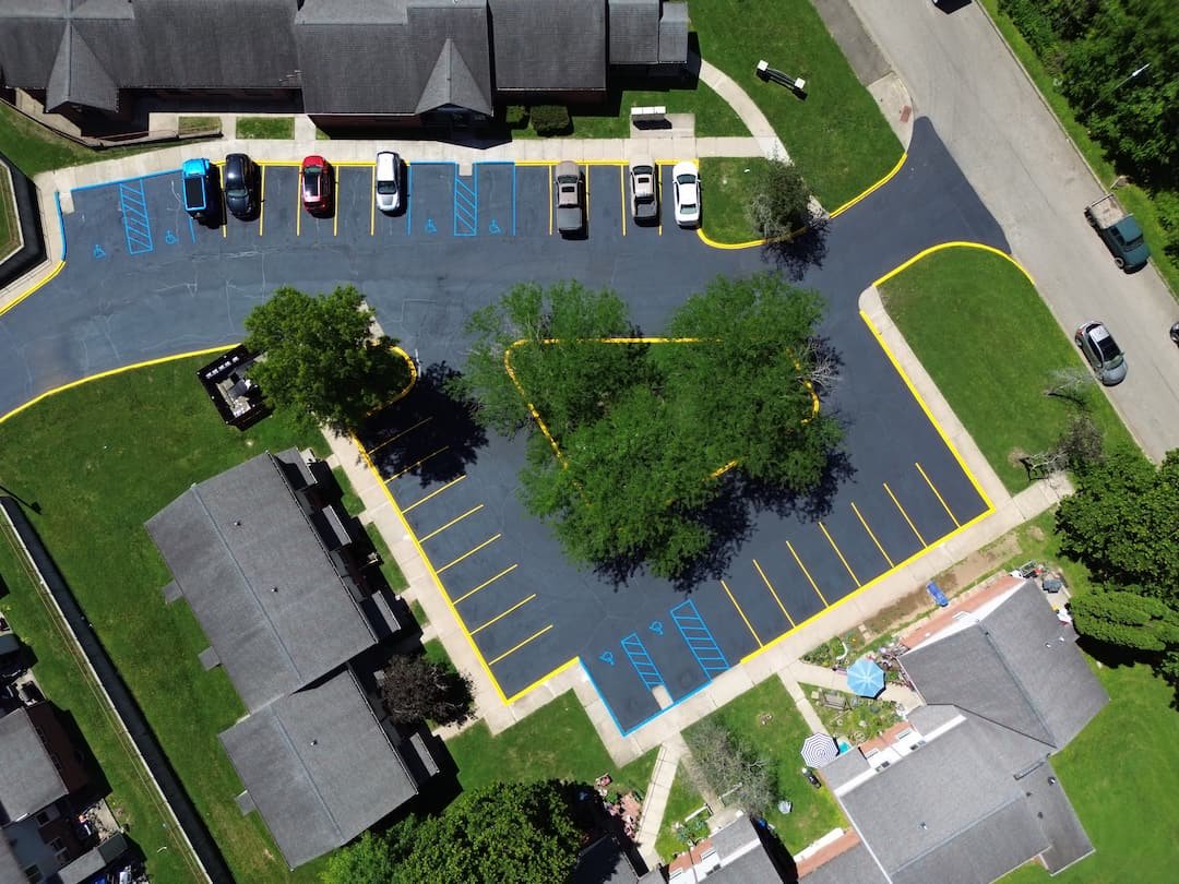Fresh asphalt sealcoating in Athens OH protecting commercial parking lot surfaces from weather and wear.