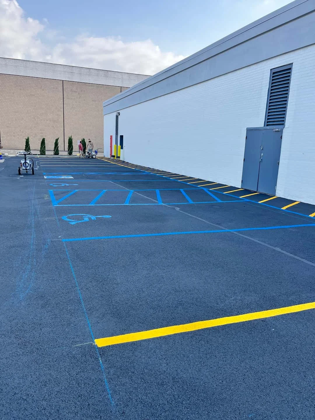 Surface preparation at Grand Central Mall in Vienna WV including wire brooming, crack cleaning, and debris removal before commercial parking lot sealcoating.