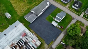 Parking lot sealcoating in Woodsfield OH with fresh black asphalt finish protecting pavement from weather and traffic damage.