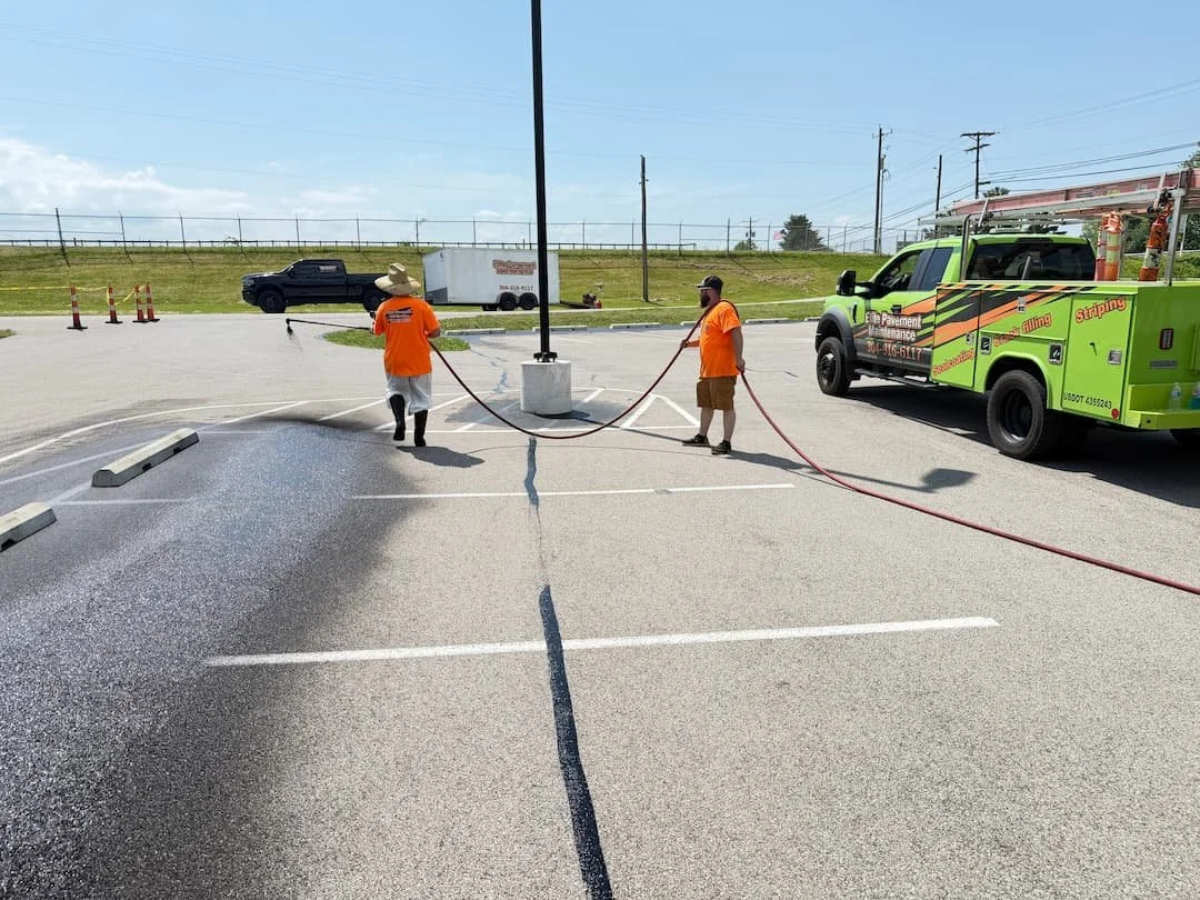 Commercial asphalt sealcoating preparation work in Ravenswood WV with detailed parking lot edging and cleaning.