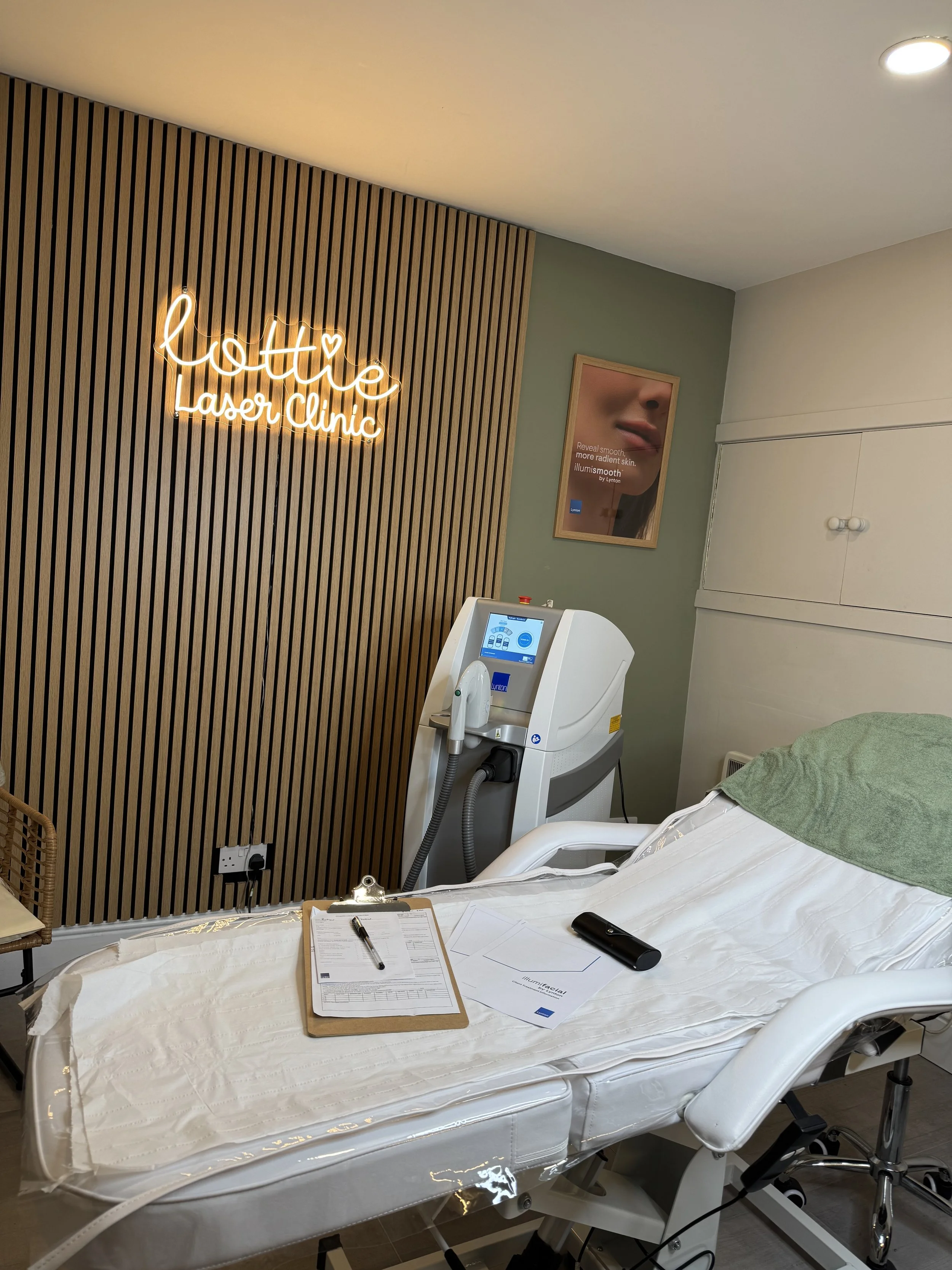 The Laser room at lottie laser clinic rossendale showing the Lynton Dynamix advanced laser machine behind the treatment bed with the consultation & medical forms laid on top