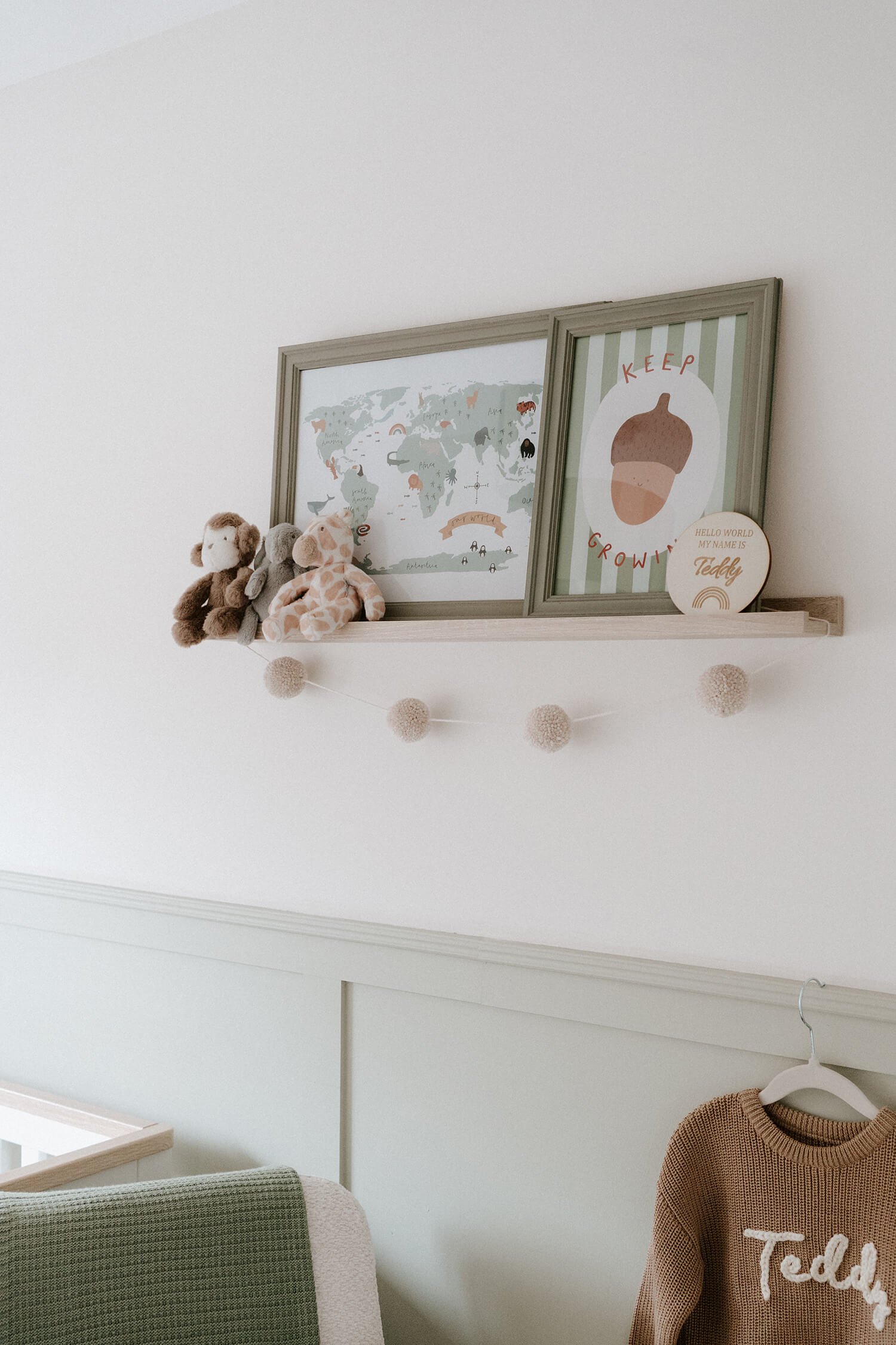 Decorative shelf with plush toys, framed world map, and artwork with the words 'Keep Growing'.