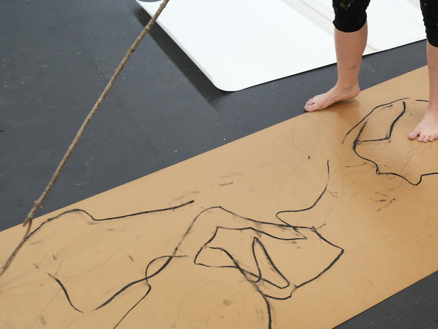Artists use bamboo sticks and their feet to create lines while working from the human form. 