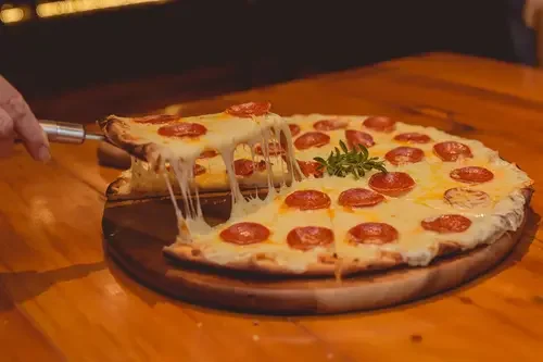 A Pizza slice being served from a pizza pie in Wisconsin Dells
