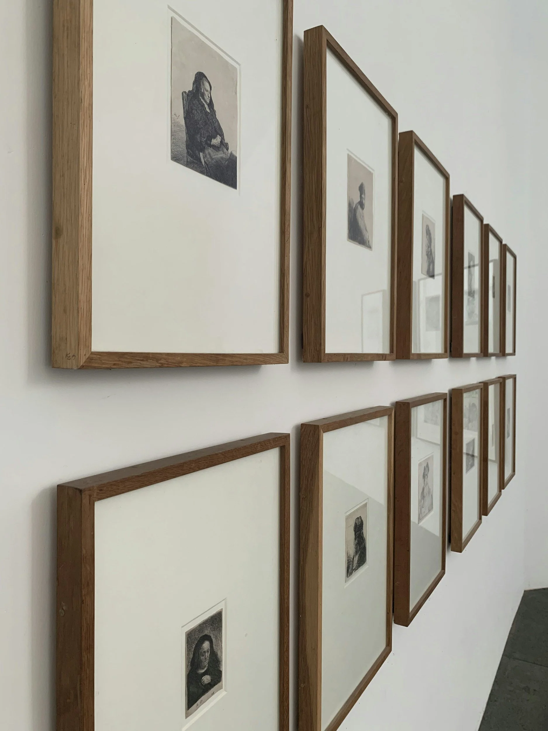 Schwarz-weiße Portraits in Holzrahmen an einer weißen Wand. KaysserArt Fotografie