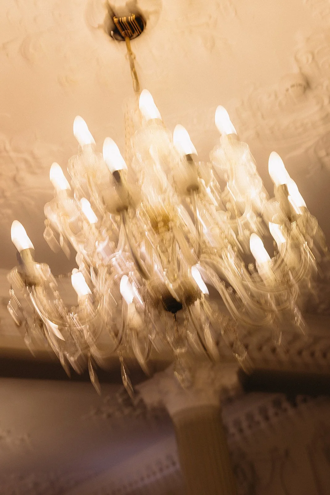 A crystal chandelier with multiple candle-shaped lights hanging from the ceiling.