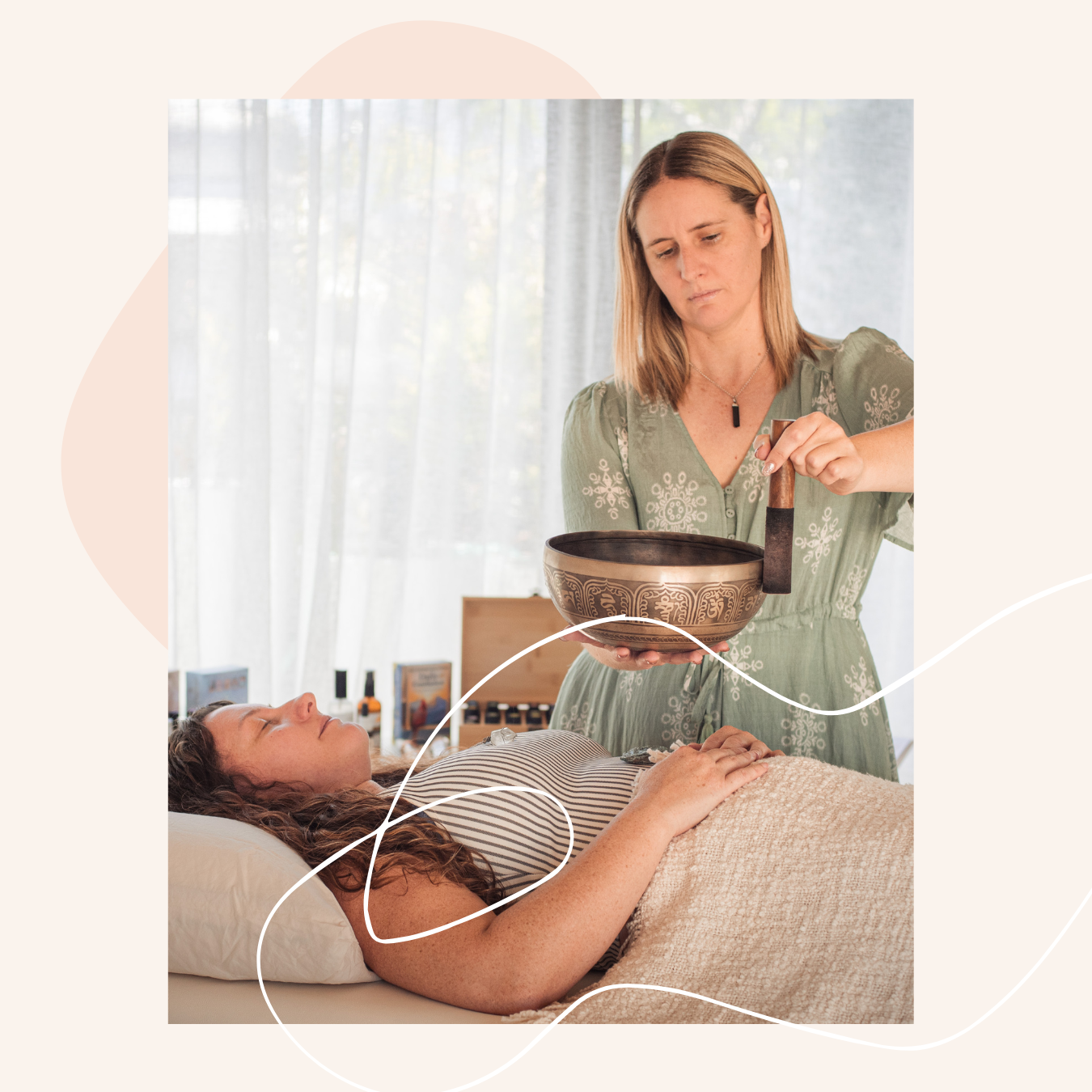 A woman laying in bed with her eyes closed, receiving a sound healing session from Jackie holding a singing bowl in a serene setting.