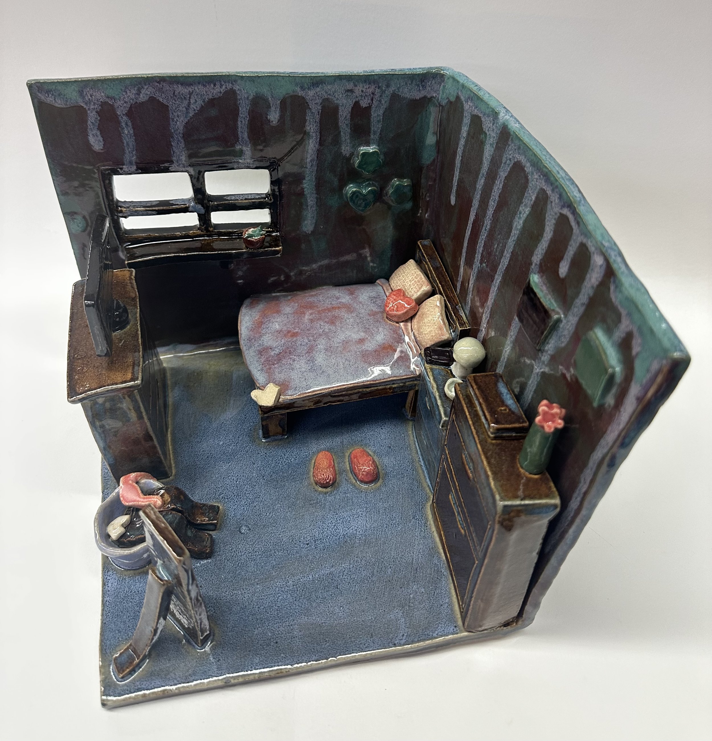 A cool-toned bedroom with an assortment of clay furniture pieces.