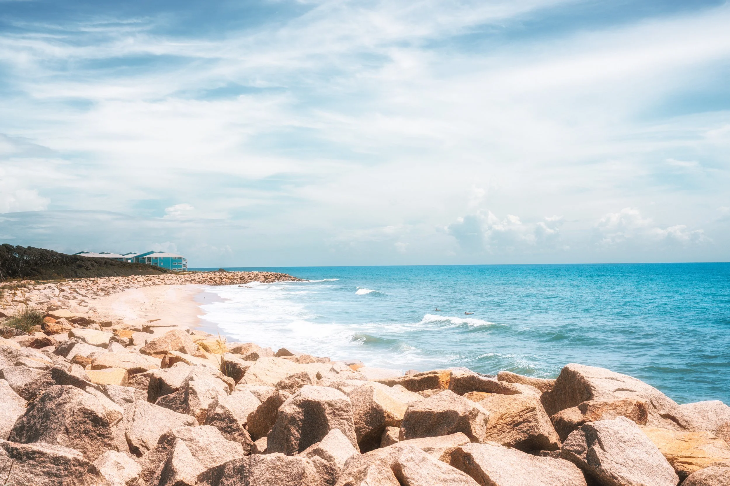Waves and shoreline textures stretch toward the horizon along the coast of North Carolina, emphasizing space, light, and the rhythm of the ocean.