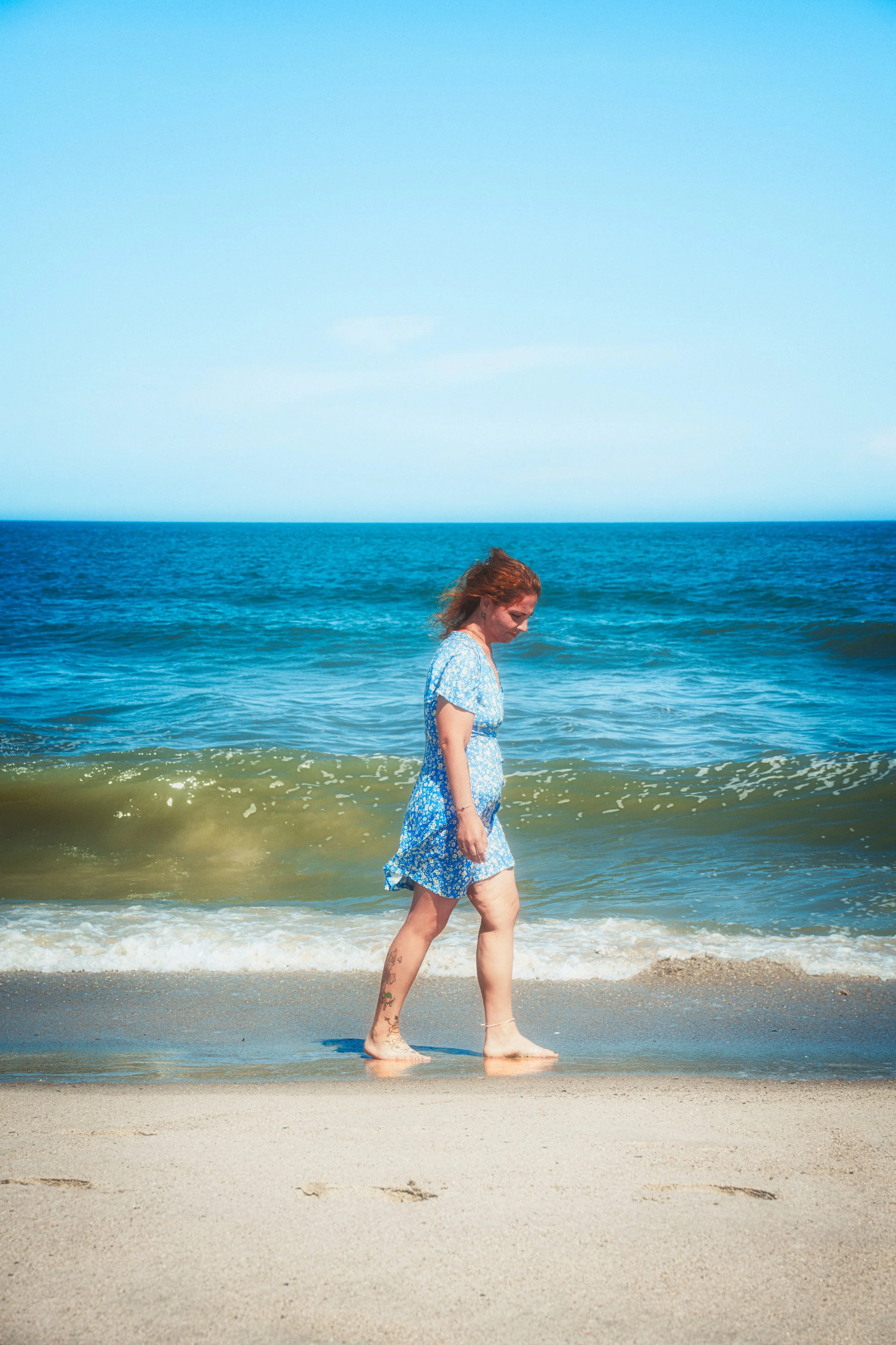 A quiet moment walking along the beach, highlighting natural movement and relaxed coastal atmosphere.