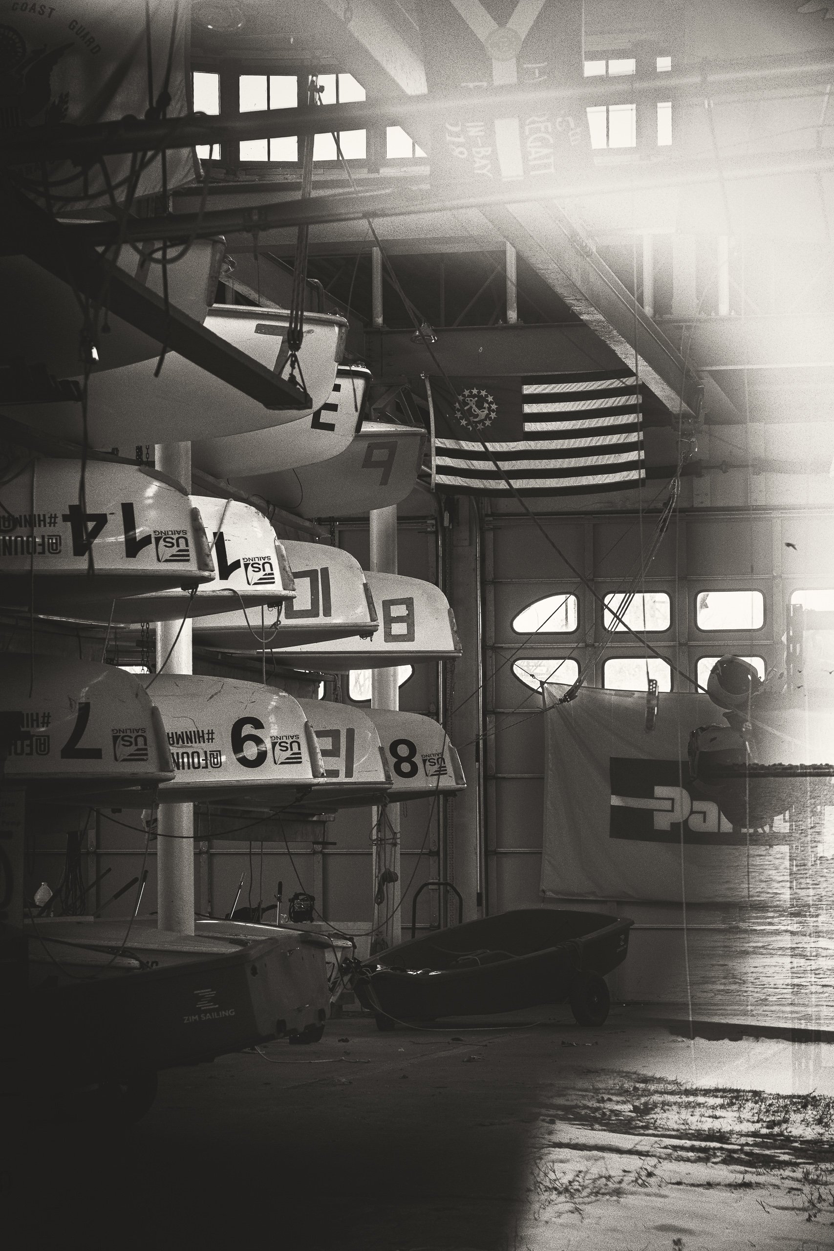 Light enters through windows inside a quiet boathouse, revealing layered textures and subtle architectural detail.