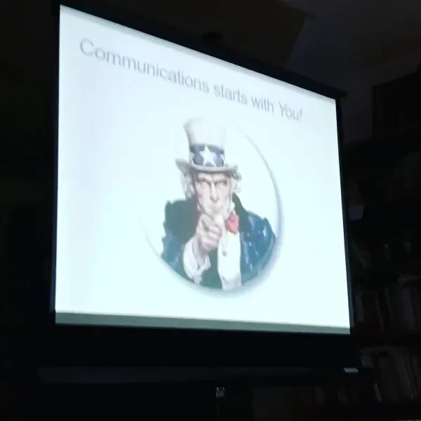 A presentation slide with the image of Uncle Sam pointing forward, wearing a star-spangled hat and suit. The slide reads 'Communications starts with You!'