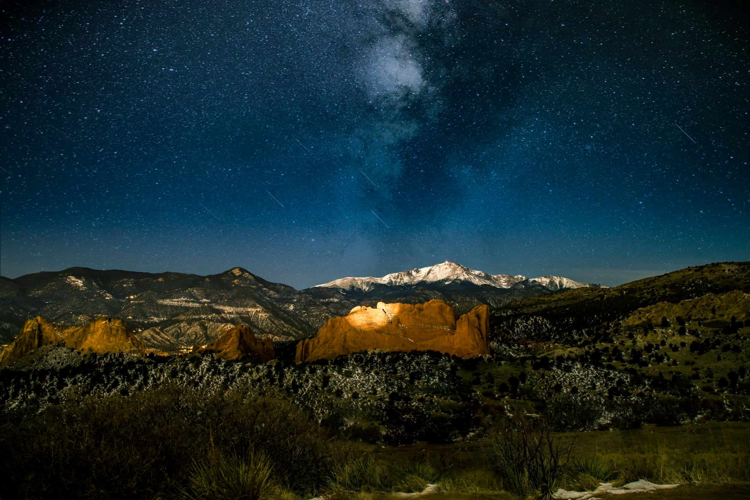 A snow-capped Pikes Peak rises above the abundant evergreen forests of Teller County.