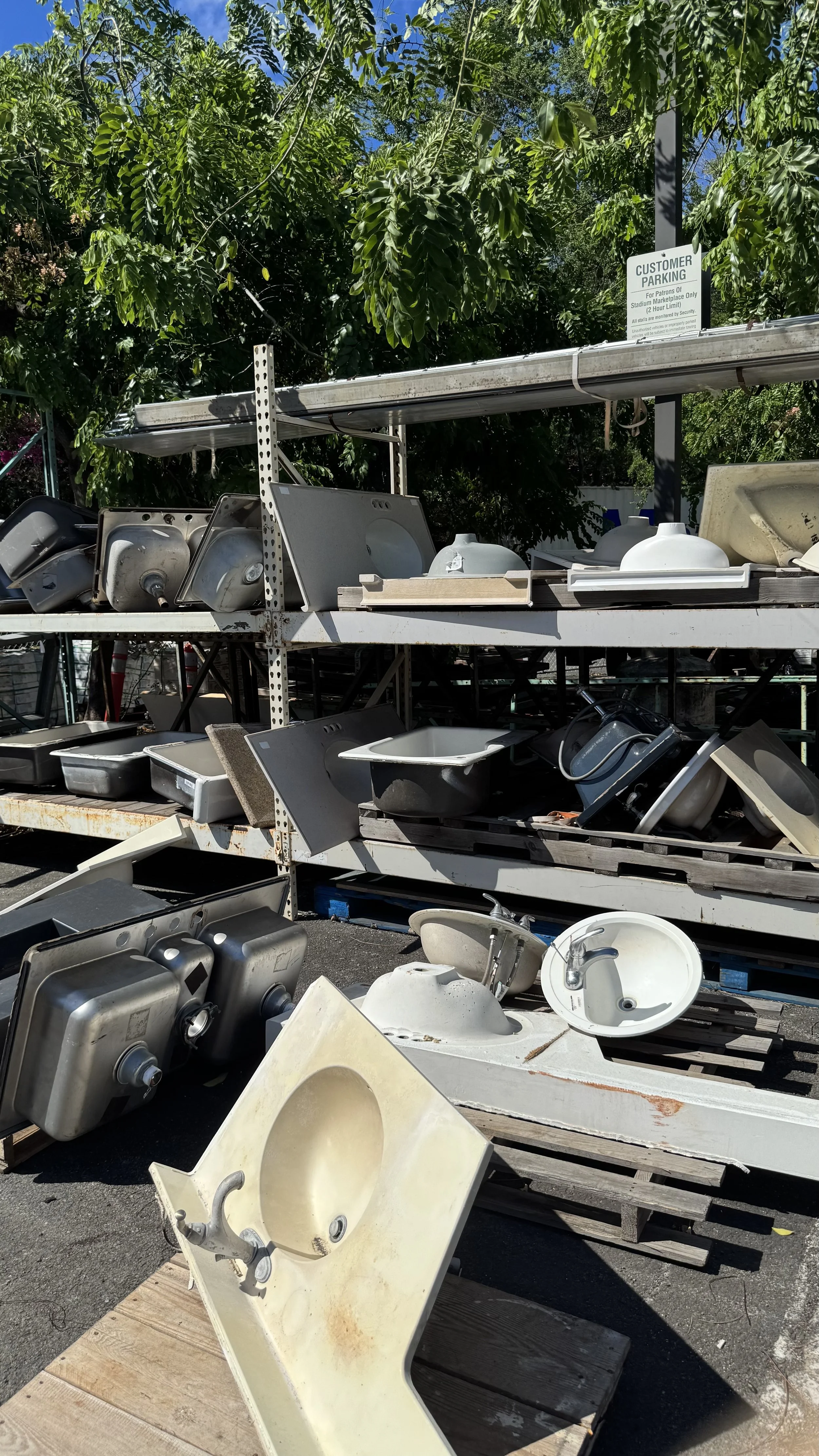 Shelves of new and used sinks stacked on racks outside in the Re-use Hawai‘i Lumberyard.