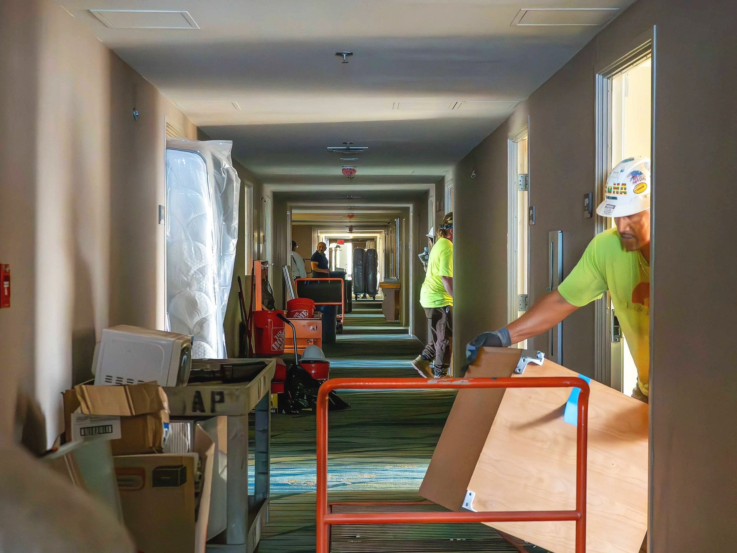 A crew of Deconstruction guys removing hotel furniture at a hotel liquidation project.