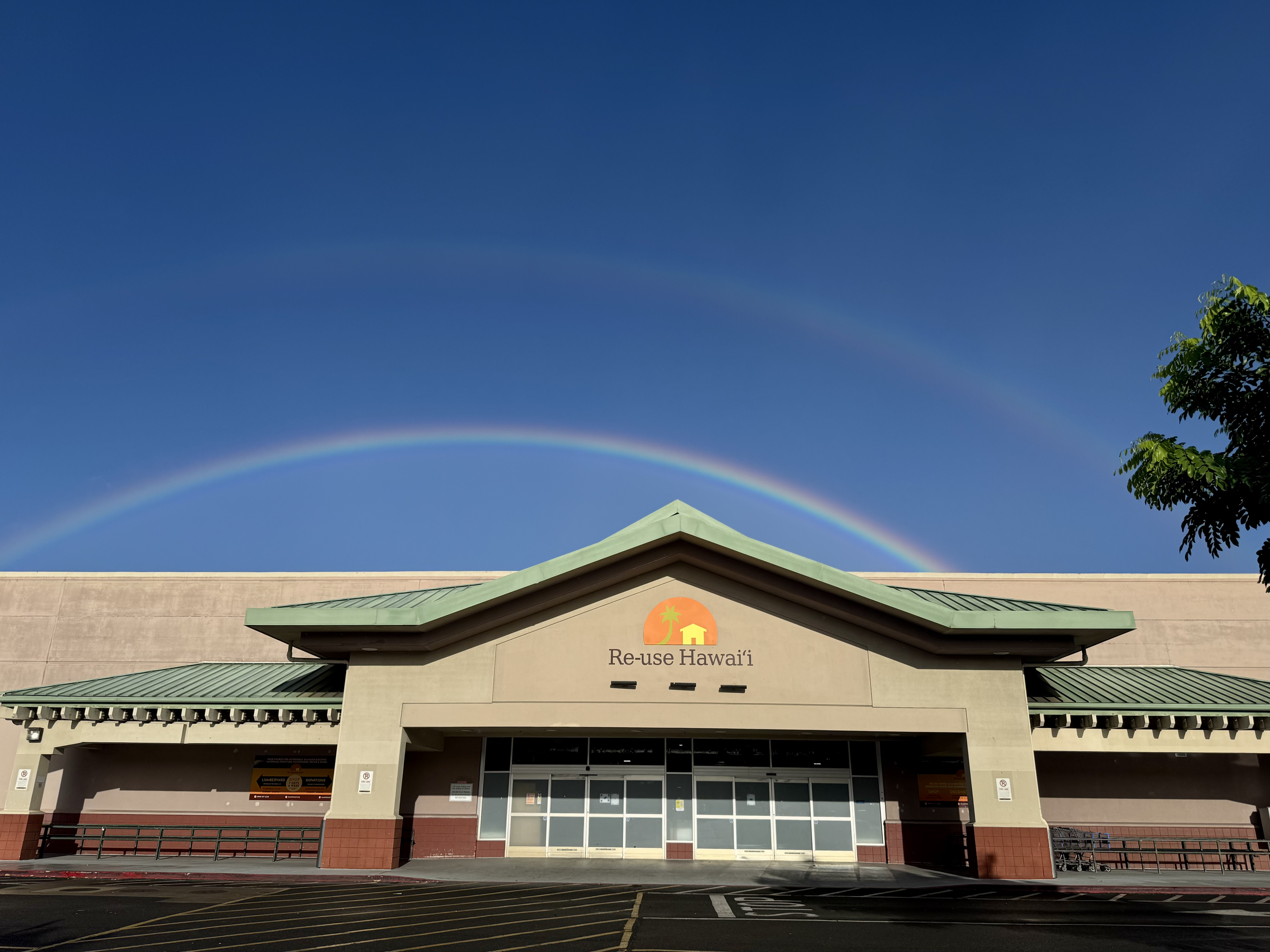 Photo of Re-use Hawai‘i storefront with a a beautiful rainbow shining directly above it in full