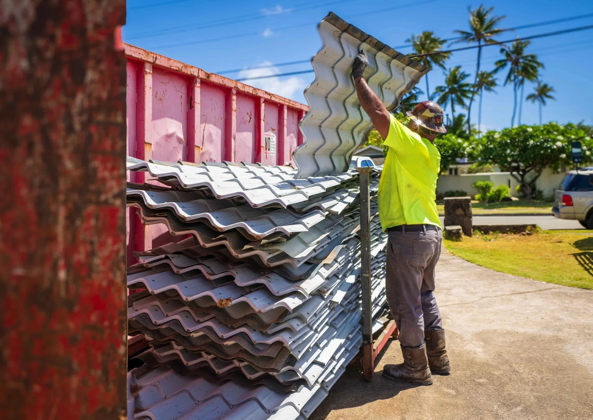 A man loading roofing materials onto a stack rack on a deconstruction project site.